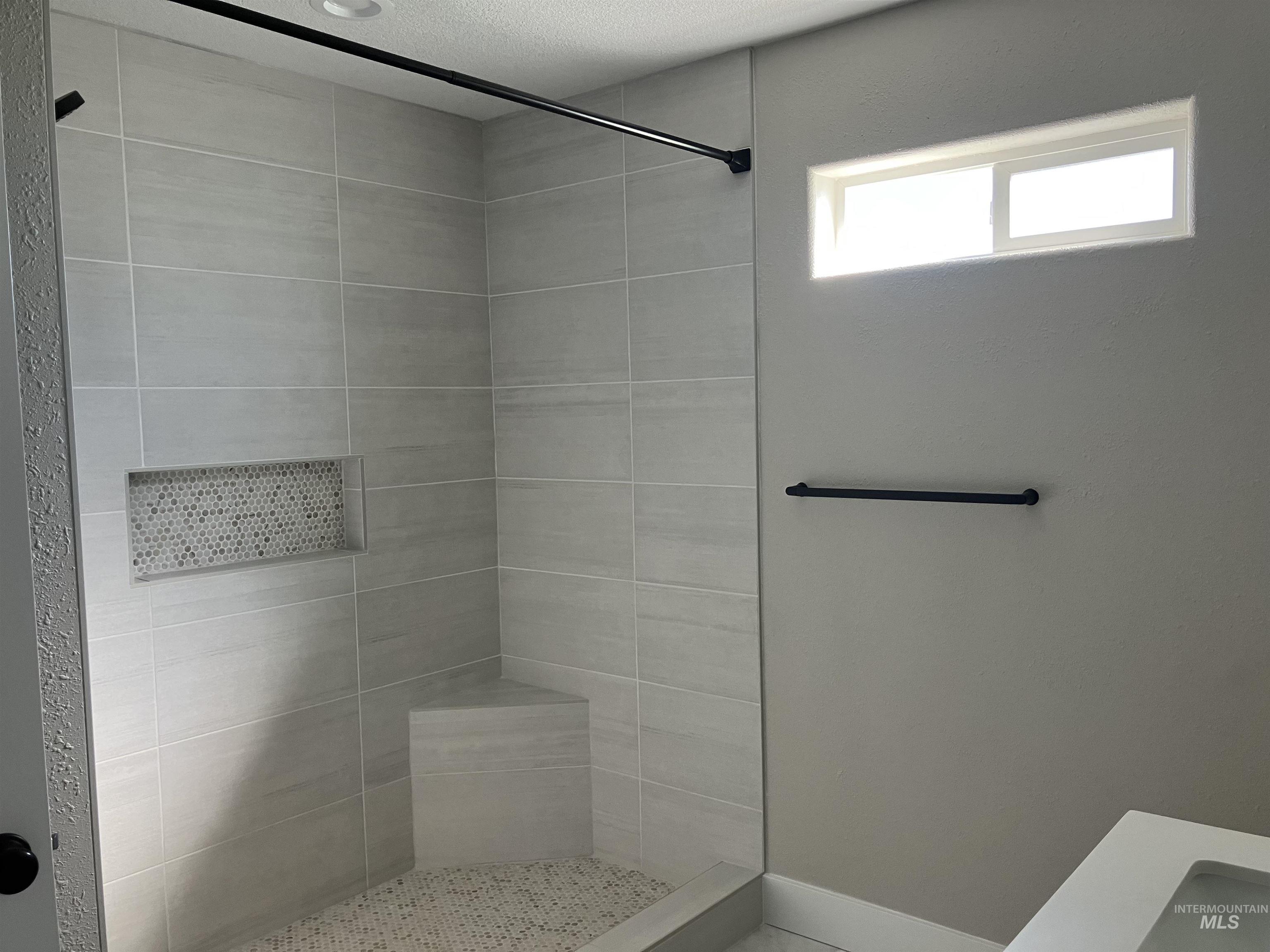 Full bathroom featuring a stall shower and a textured ceiling