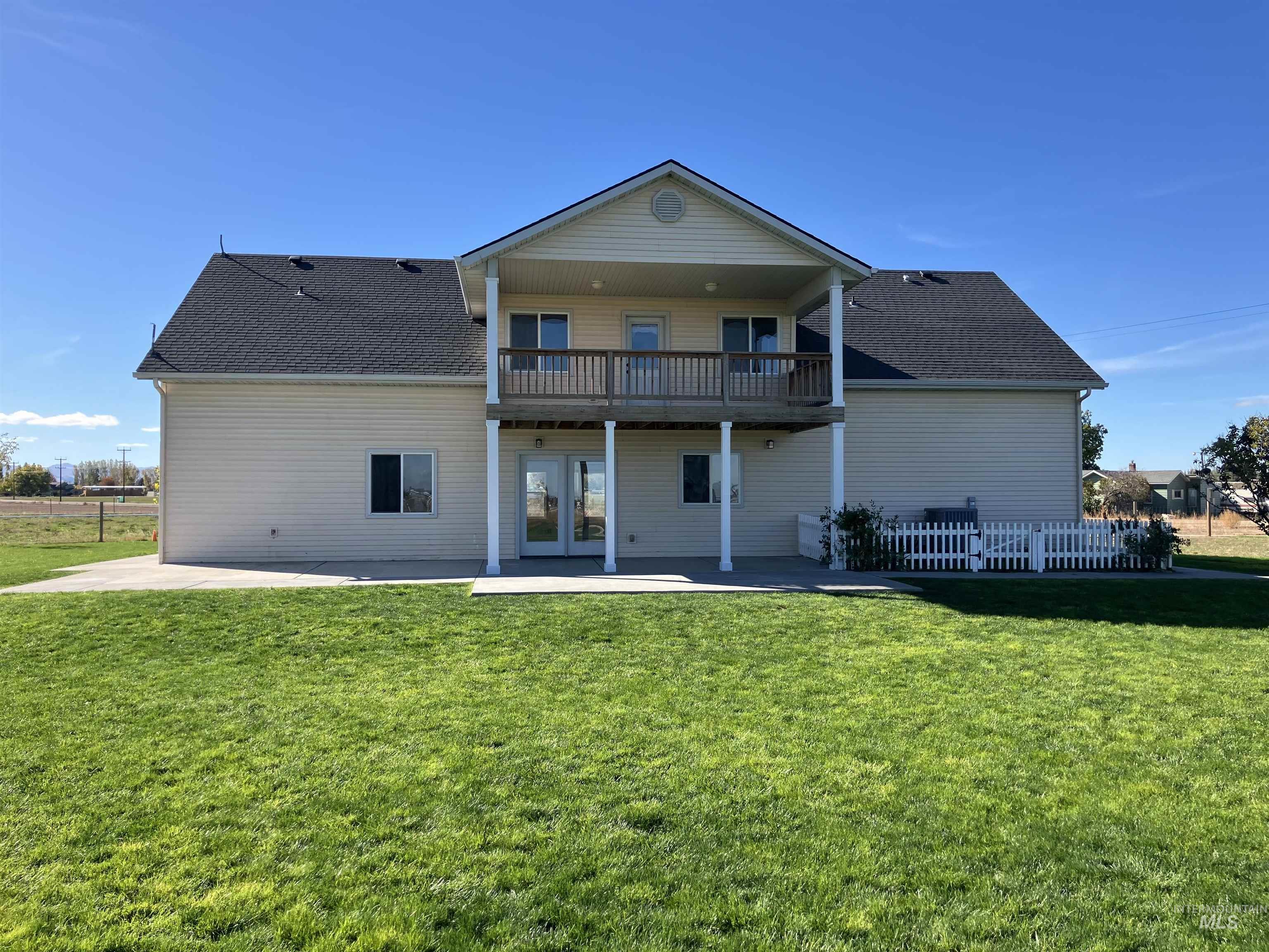 Back of house featuring a patio area, roof with shingles, french doors, and a balcony