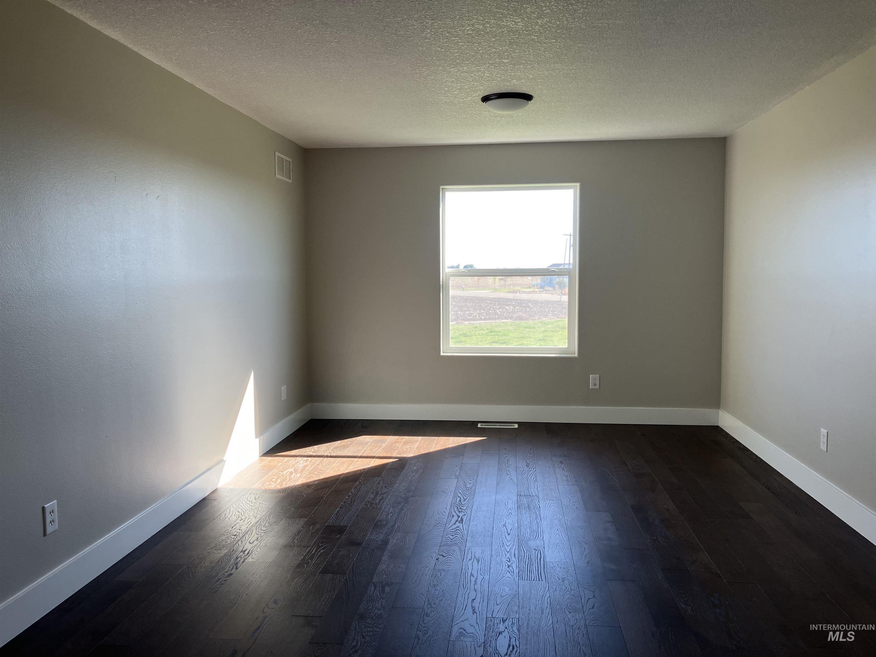 Bedroom with dark wood-style floors and a textured ceiling and a 8' x 19' 