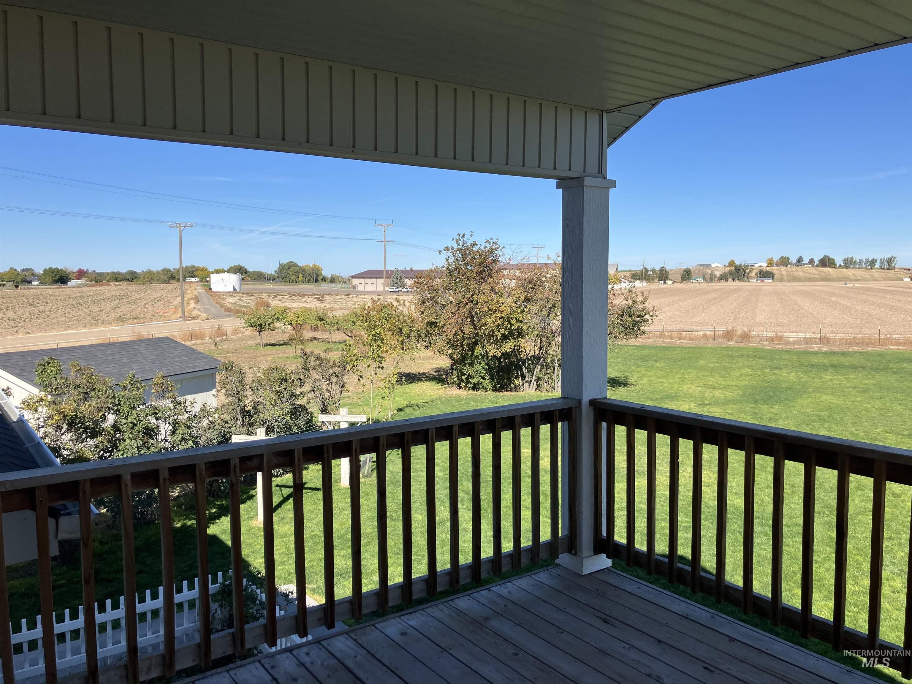 Balcony from upper bedroom featuring a view of countryside and a lawn