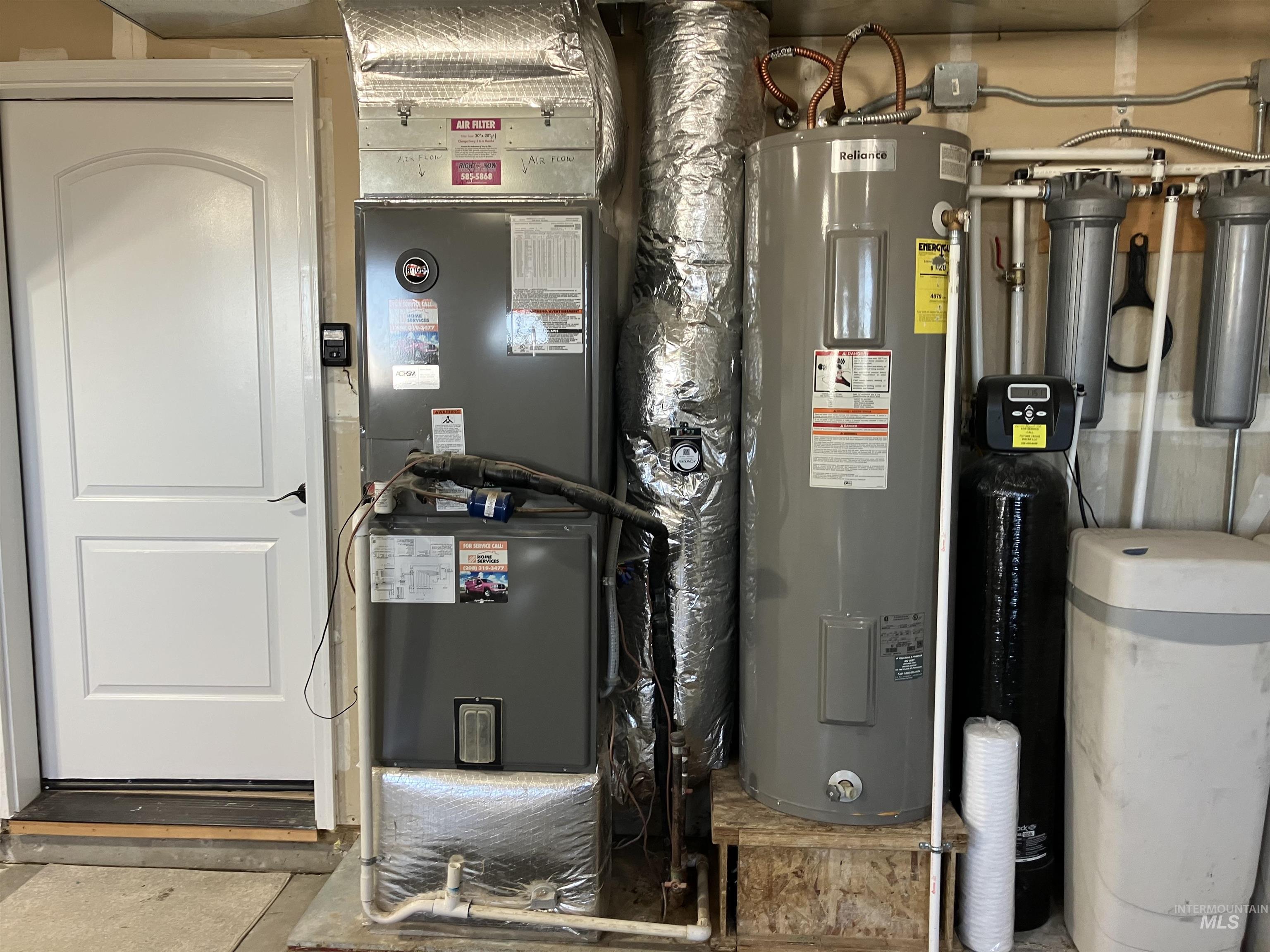 Utility room featuring electric water heater and heating unit
