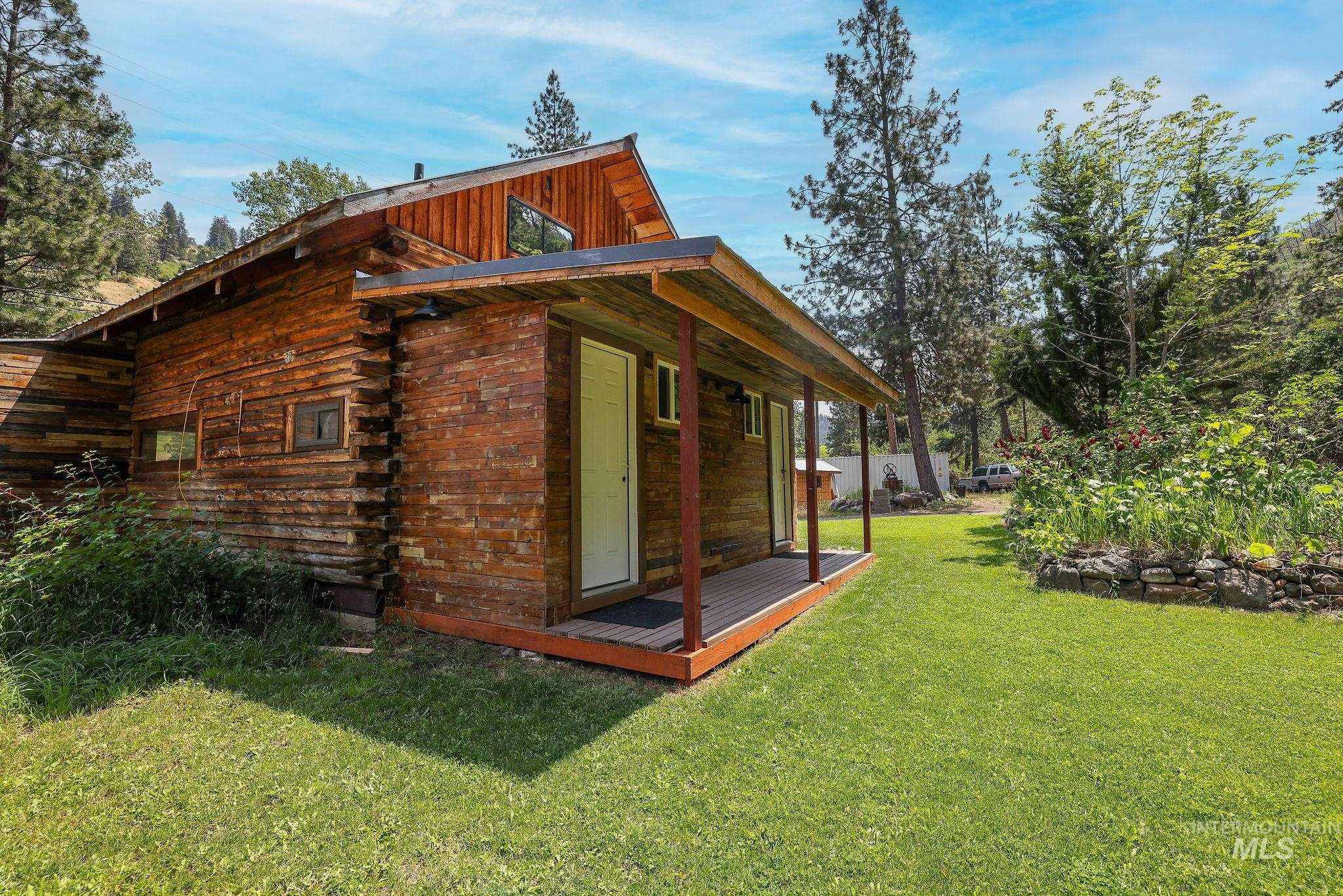View of side of home with a yard and log siding