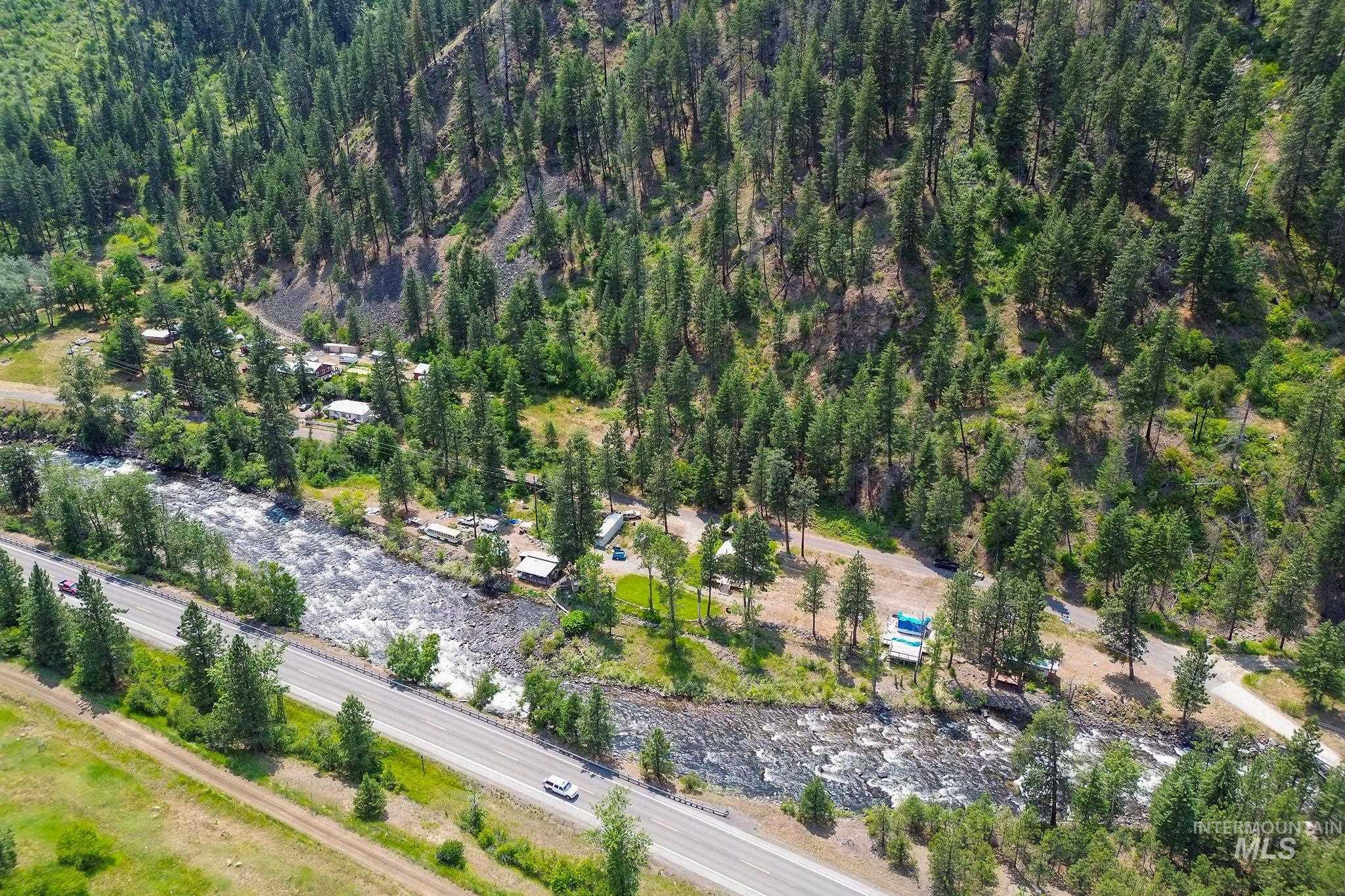 Aerial view of property and surrounding area featuring a forest