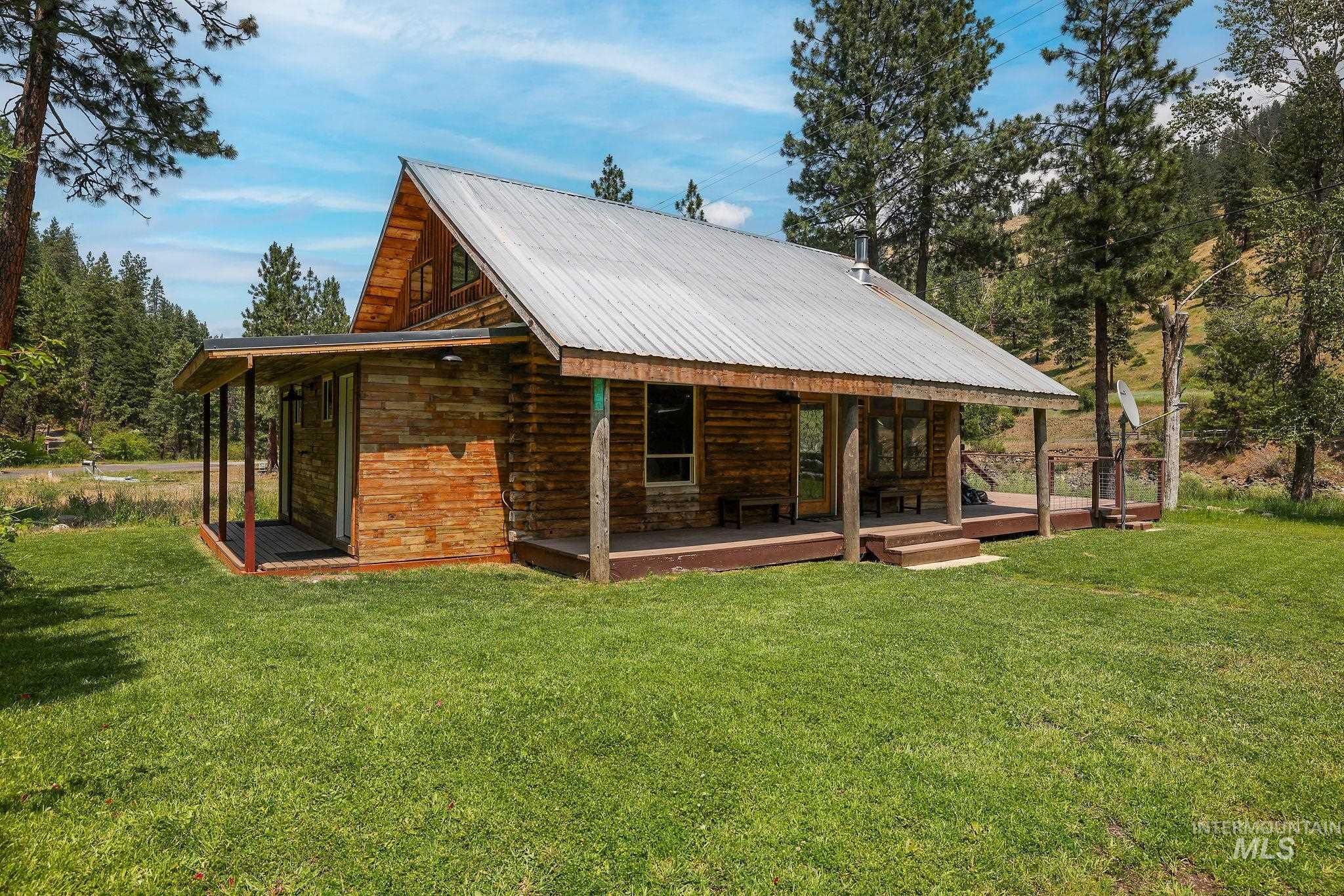 Rear view of property with a lawn, a metal roof, and a porch