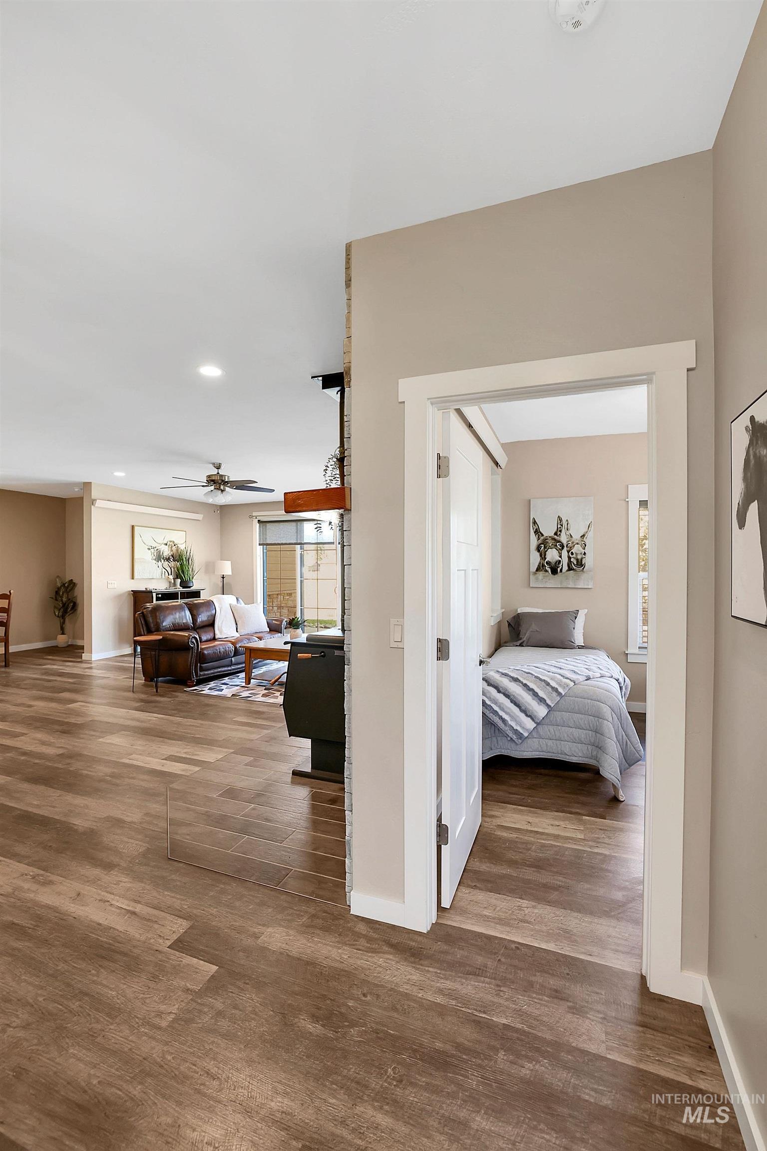 Hallway with dark wood-style flooring, plenty of natural light, and recessed lighting