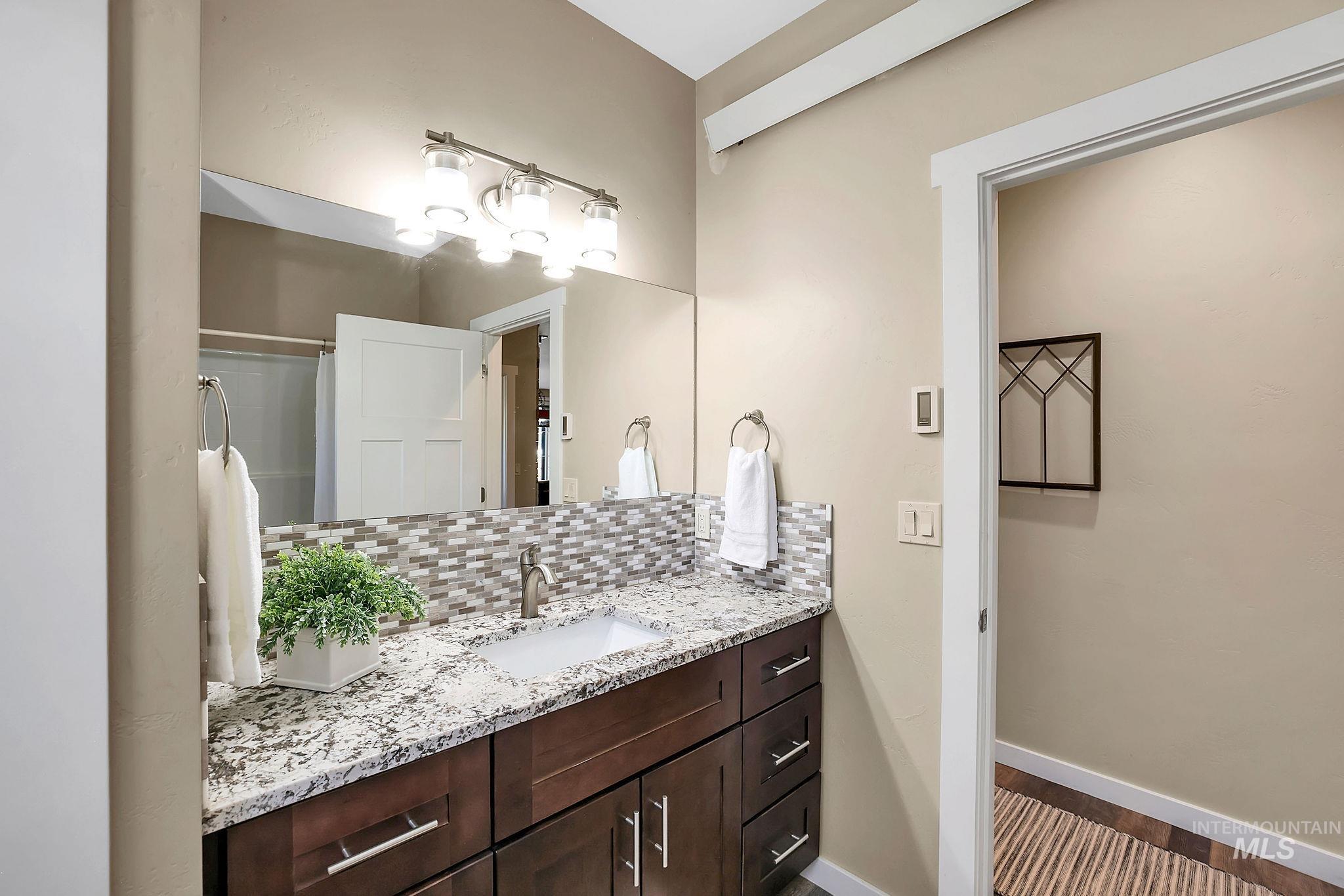 Full bathroom featuring decorative backsplash, vanity, and a shower with shower curtain