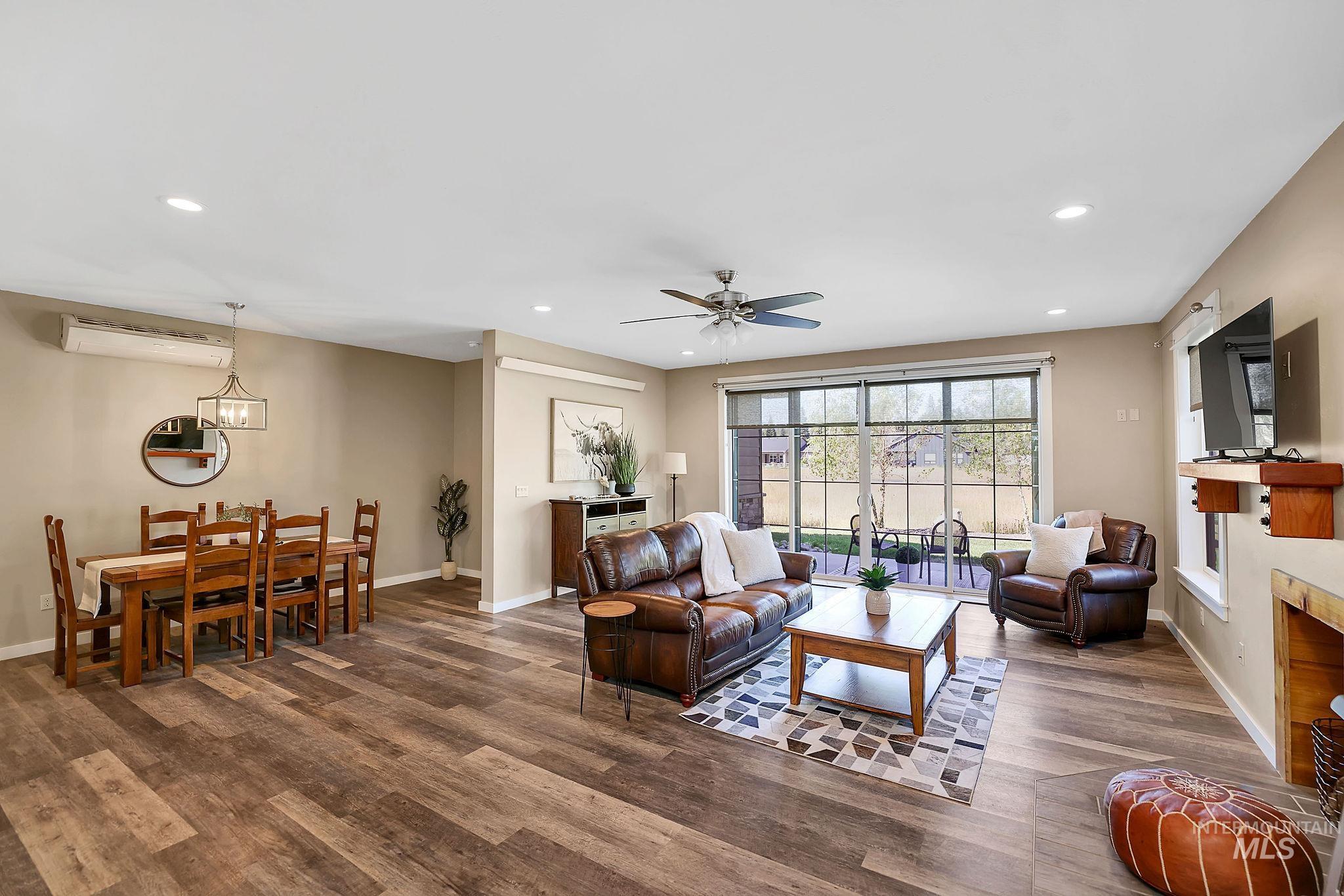 Living room featuring recessed lighting, a fireplace, wood finished floors, ceiling fan, and a wall unit AC