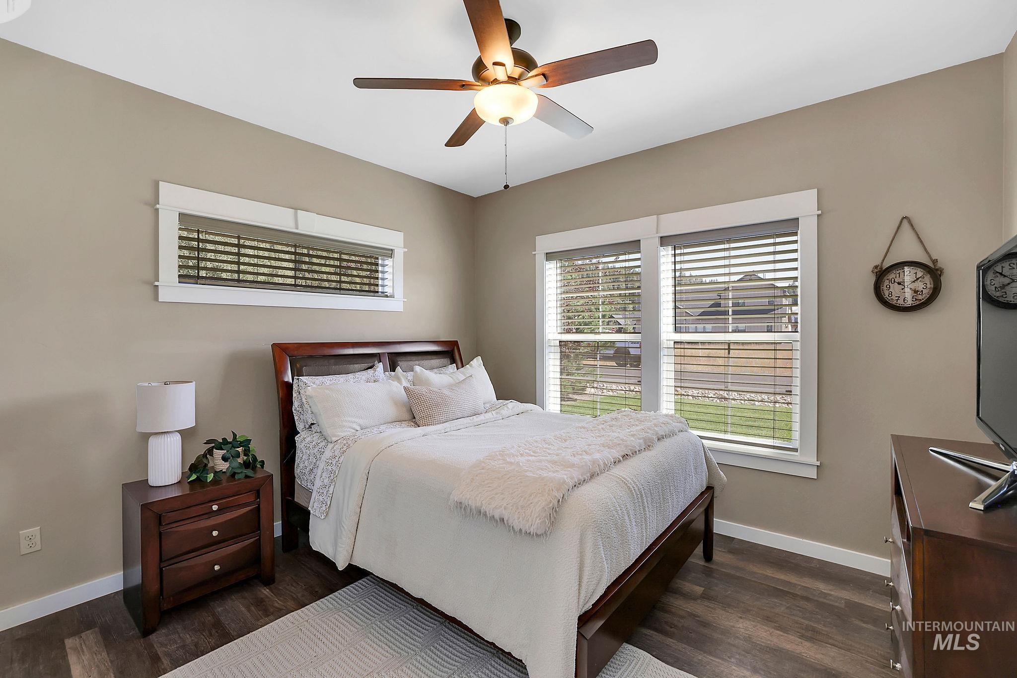 Bedroom with a ceiling fan and dark wood finished floors