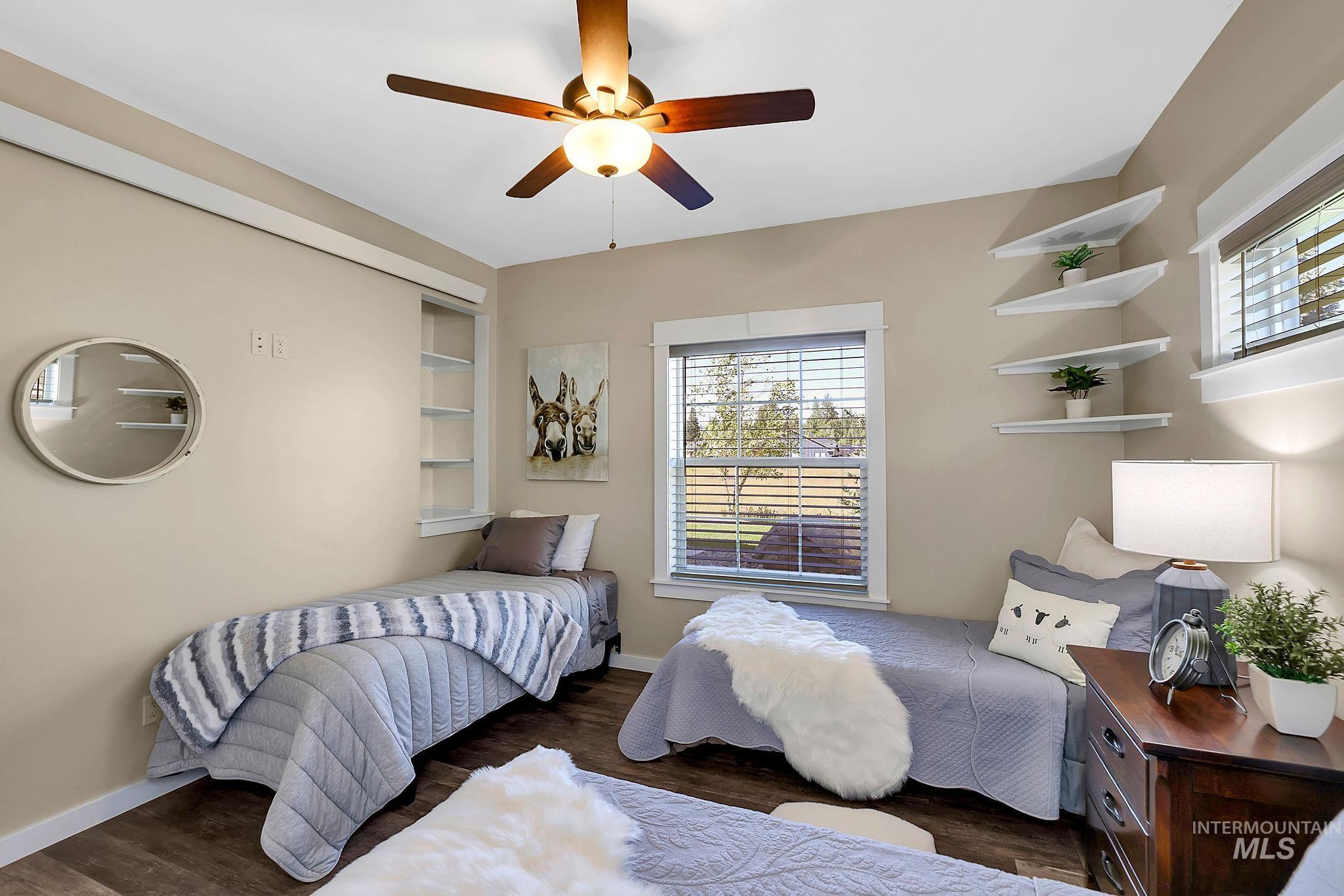 Bedroom featuring multiple windows, dark wood-type flooring, and ceiling fan