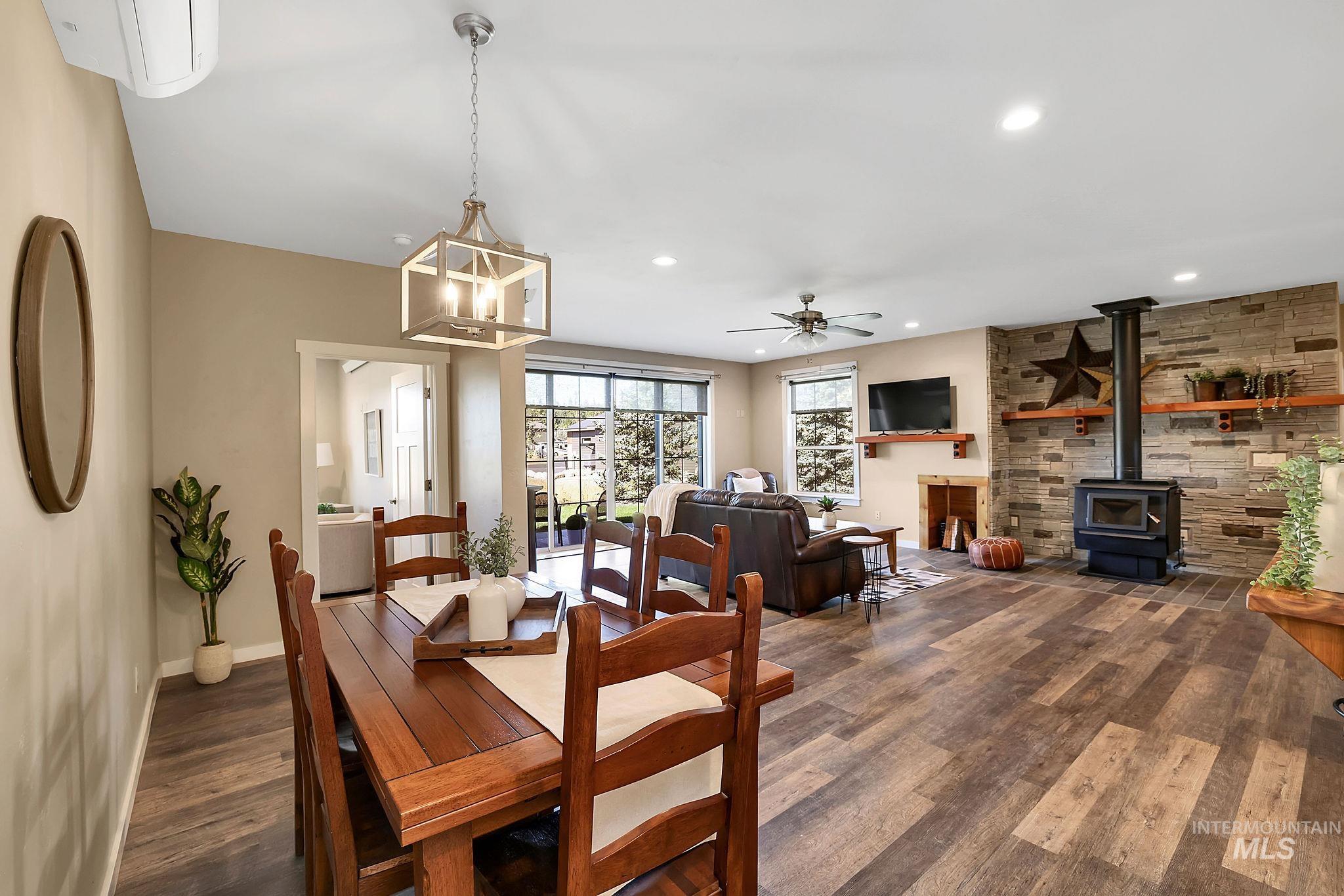 Dining area featuring a wood stove, dark wood finished floors, recessed lighting, and a ceiling fan