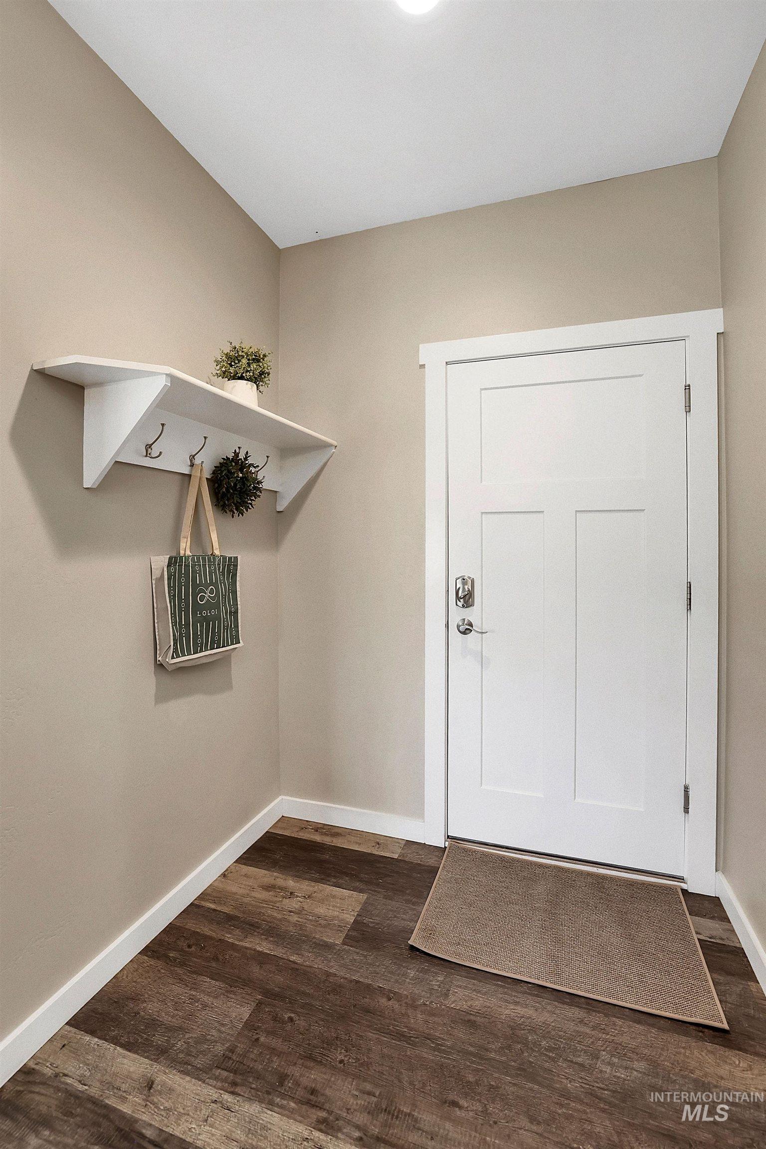 Doorway to outside with baseboards and wood finished floors