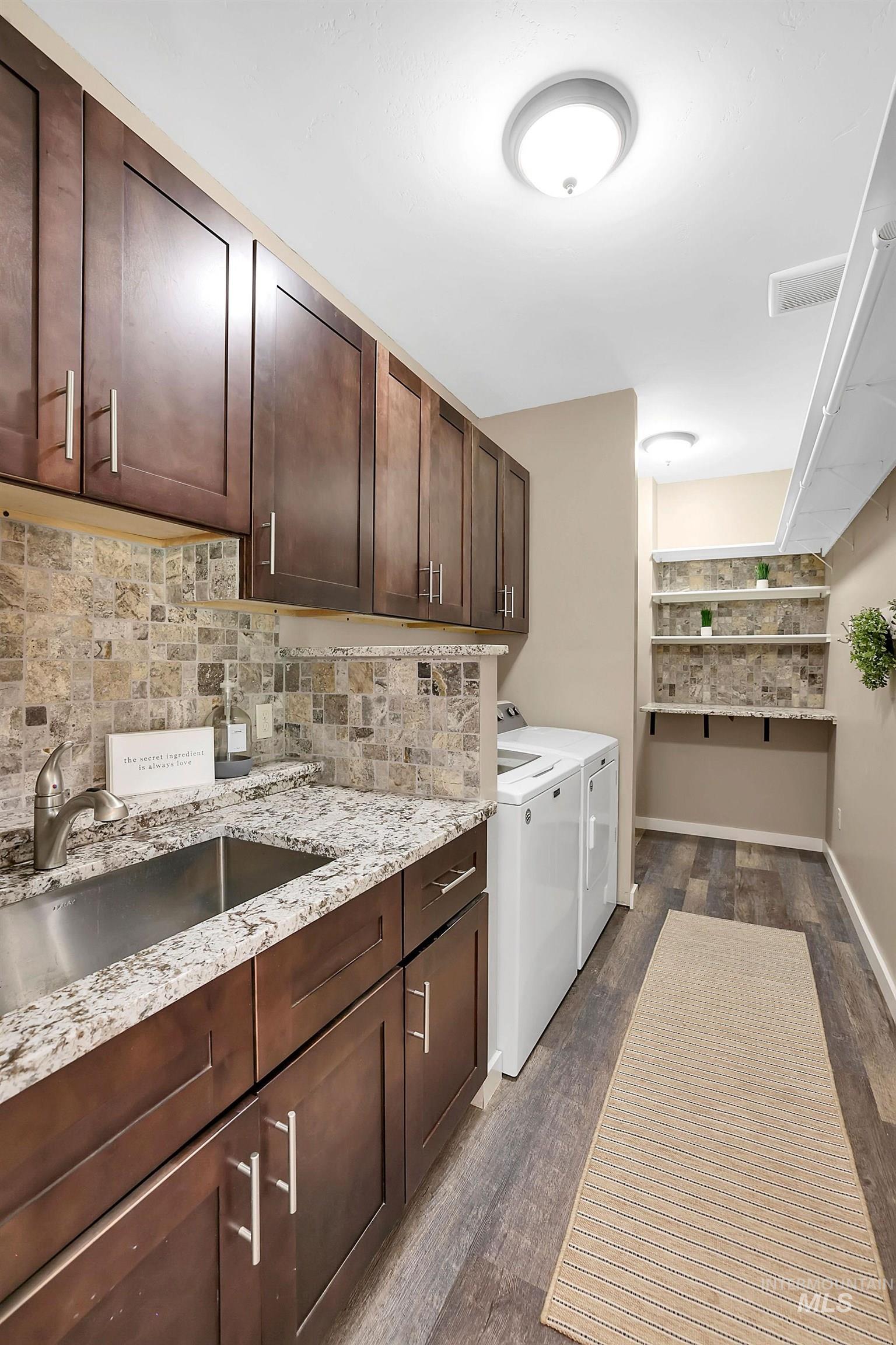 Laundry area with washer and clothes dryer, dark wood-type flooring, and cabinet space