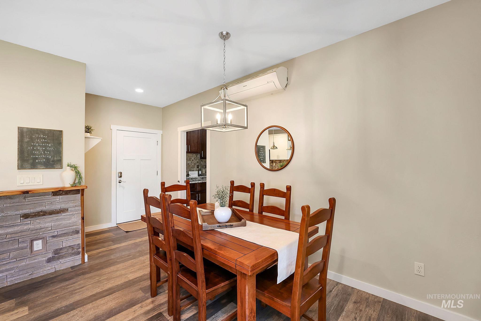 Dining area with dark wood-style flooring, a wall mounted AC, a chandelier, and recessed lighting