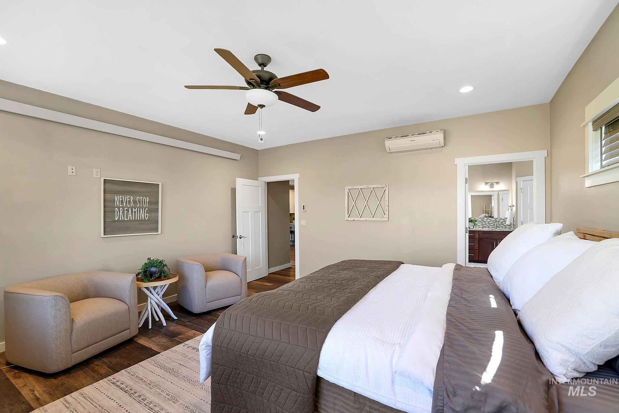 Bedroom featuring ensuite bath, wood finished floors, ceiling fan, recessed lighting, and an AC wall unit