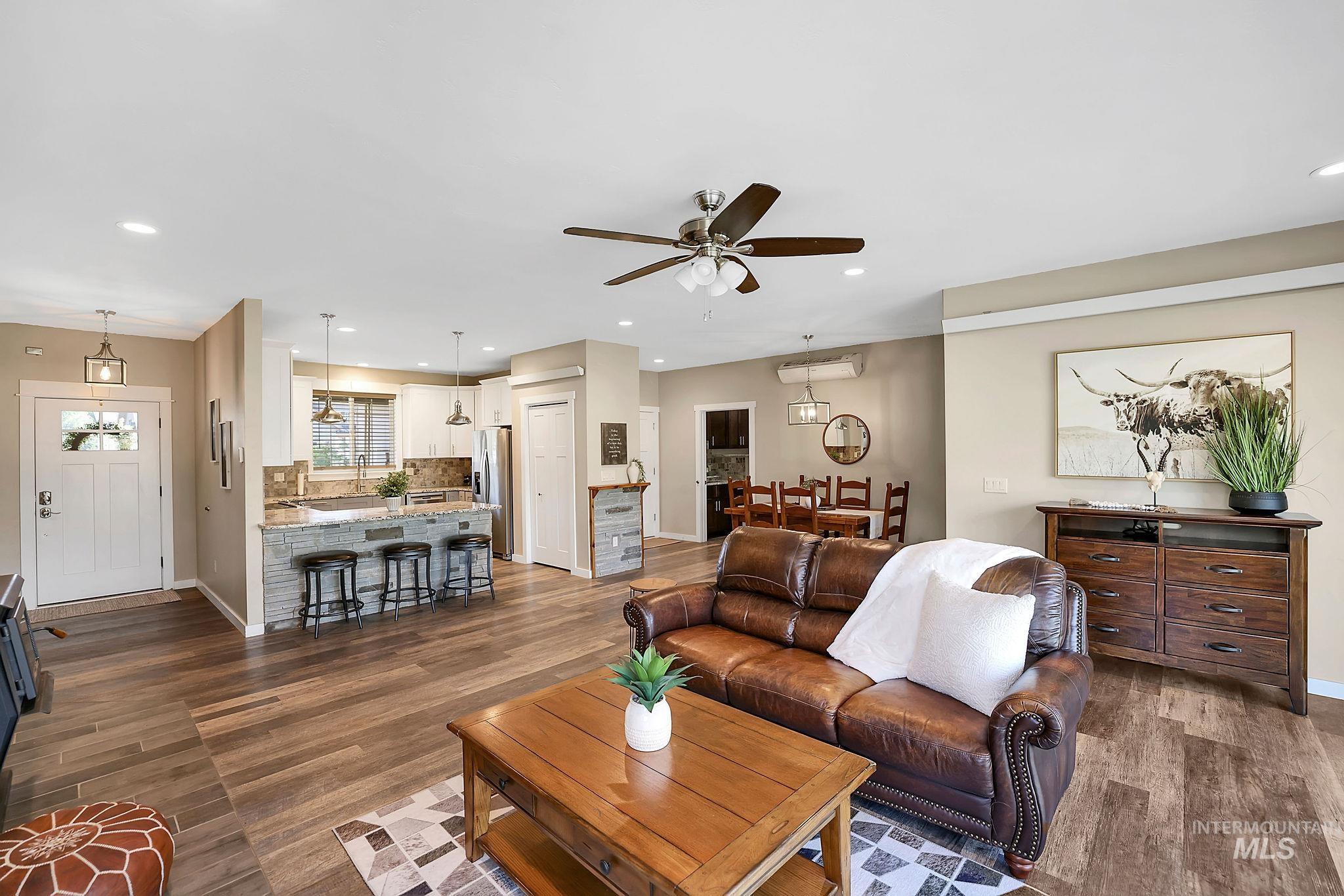 Living room featuring recessed lighting, dark wood-style flooring, and a ceiling fan
