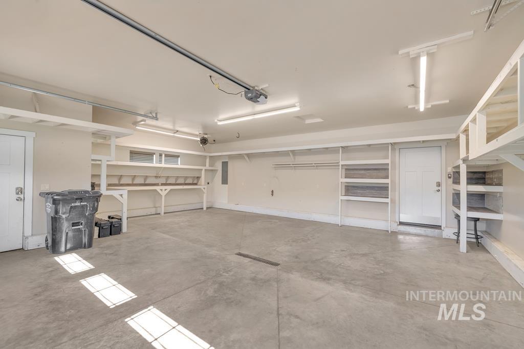 Garage with a garage door opener and baseboards