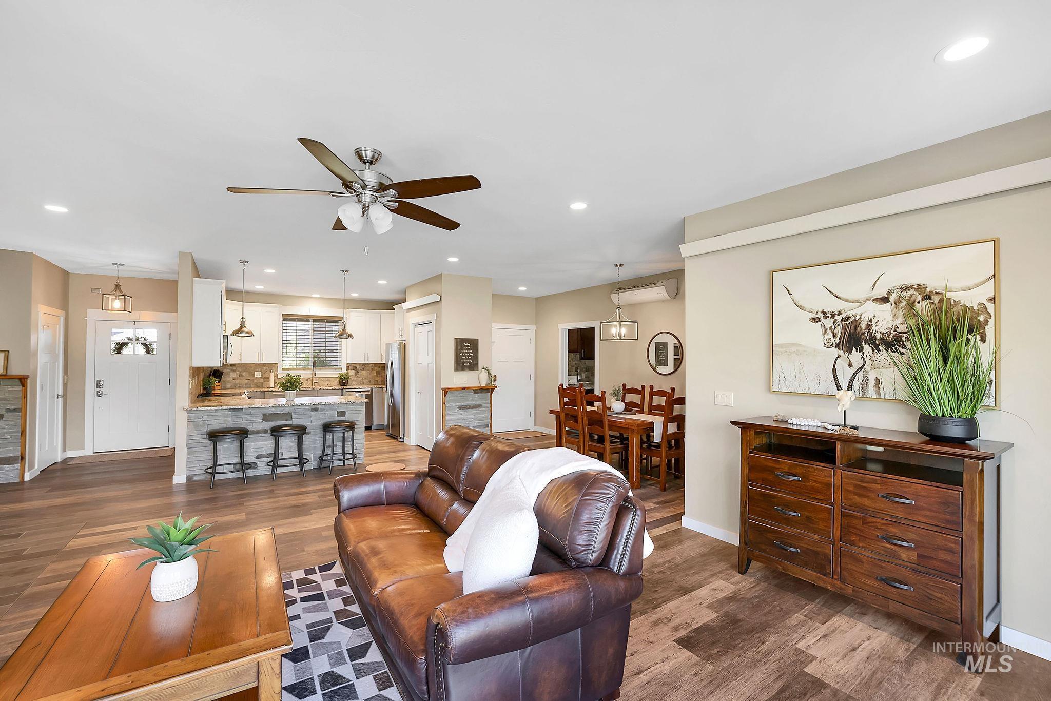 Living room with wood finished floors, recessed lighting, and a ceiling fan
