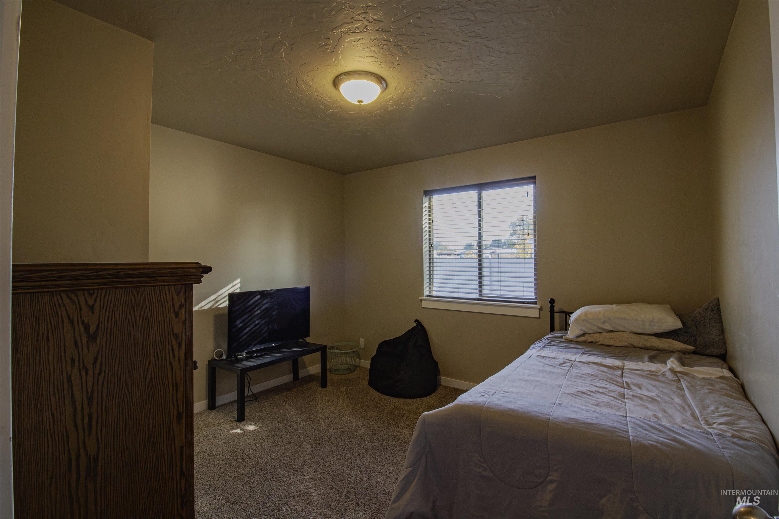 Bedroom featuring carpet floors and a textured ceiling