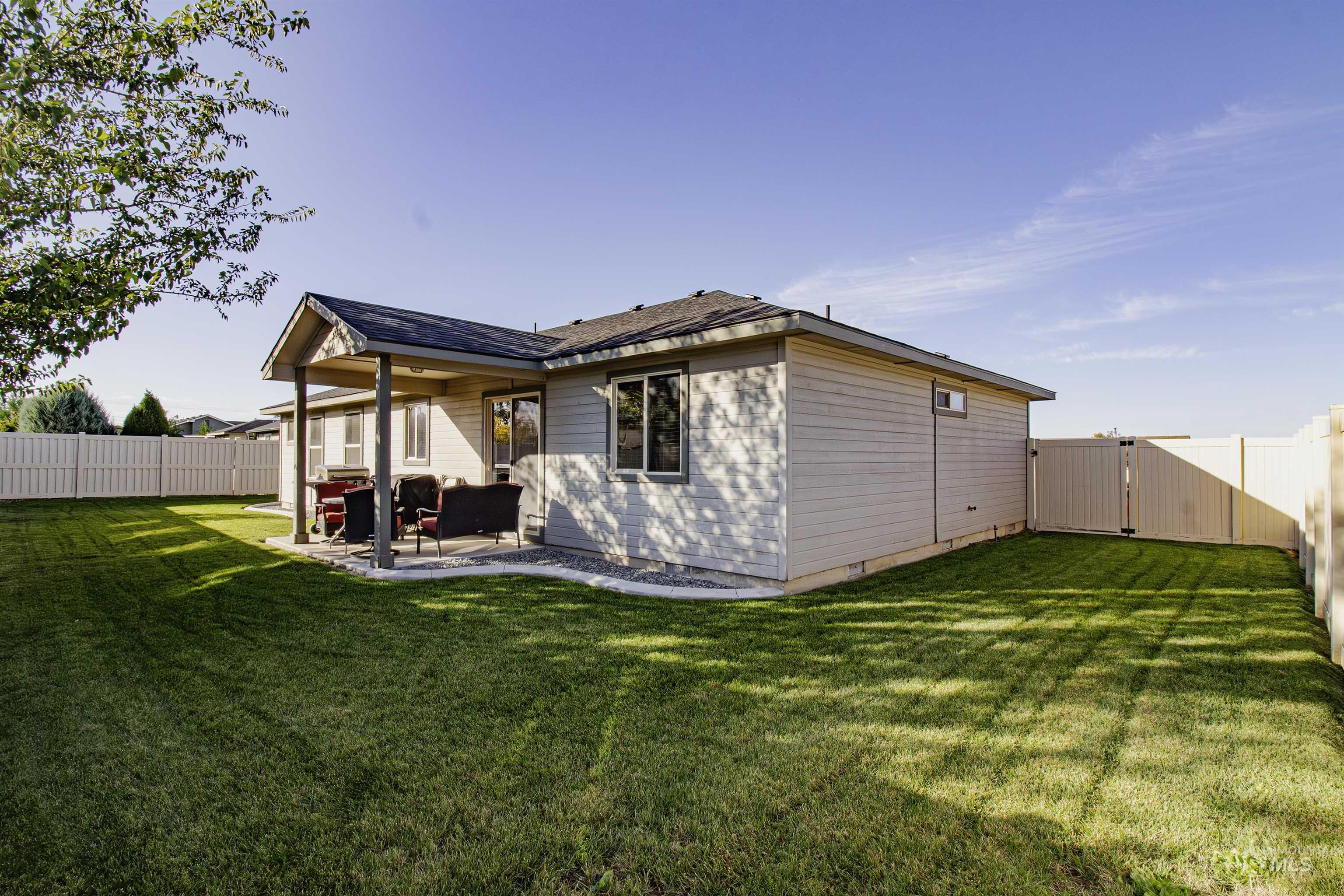 Rear view of property with a fenced backyard, a patio, a gate, and roof with shingles