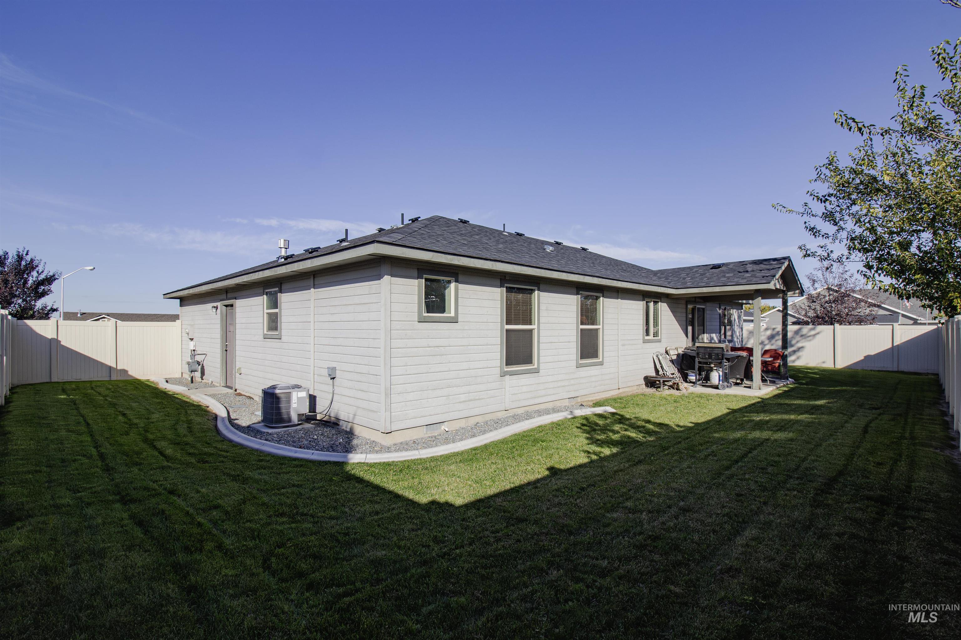 Back of property featuring a fenced backyard and a patio