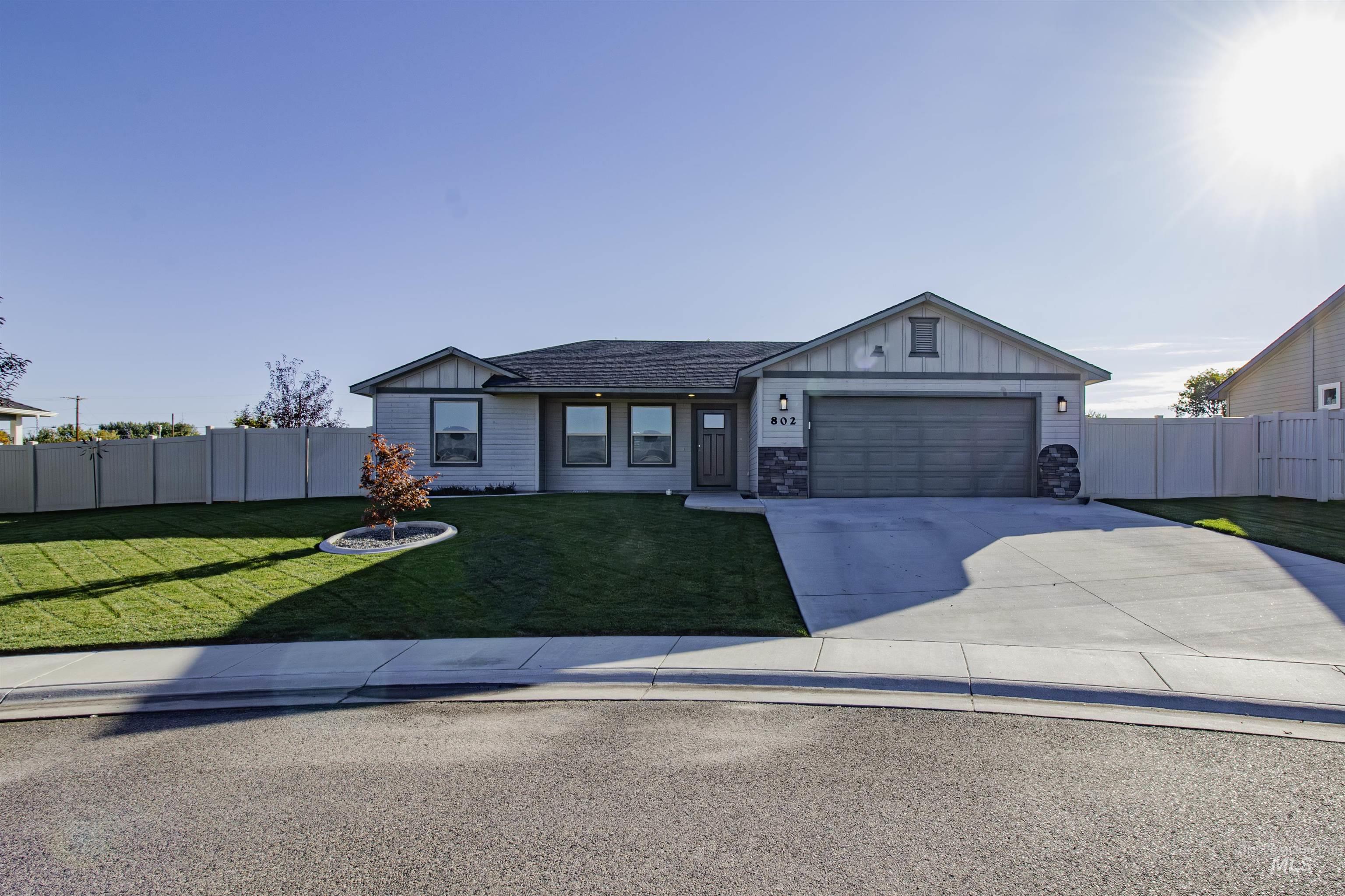 Single story home with board and batten siding, concrete driveway, stone siding, and an attached garage