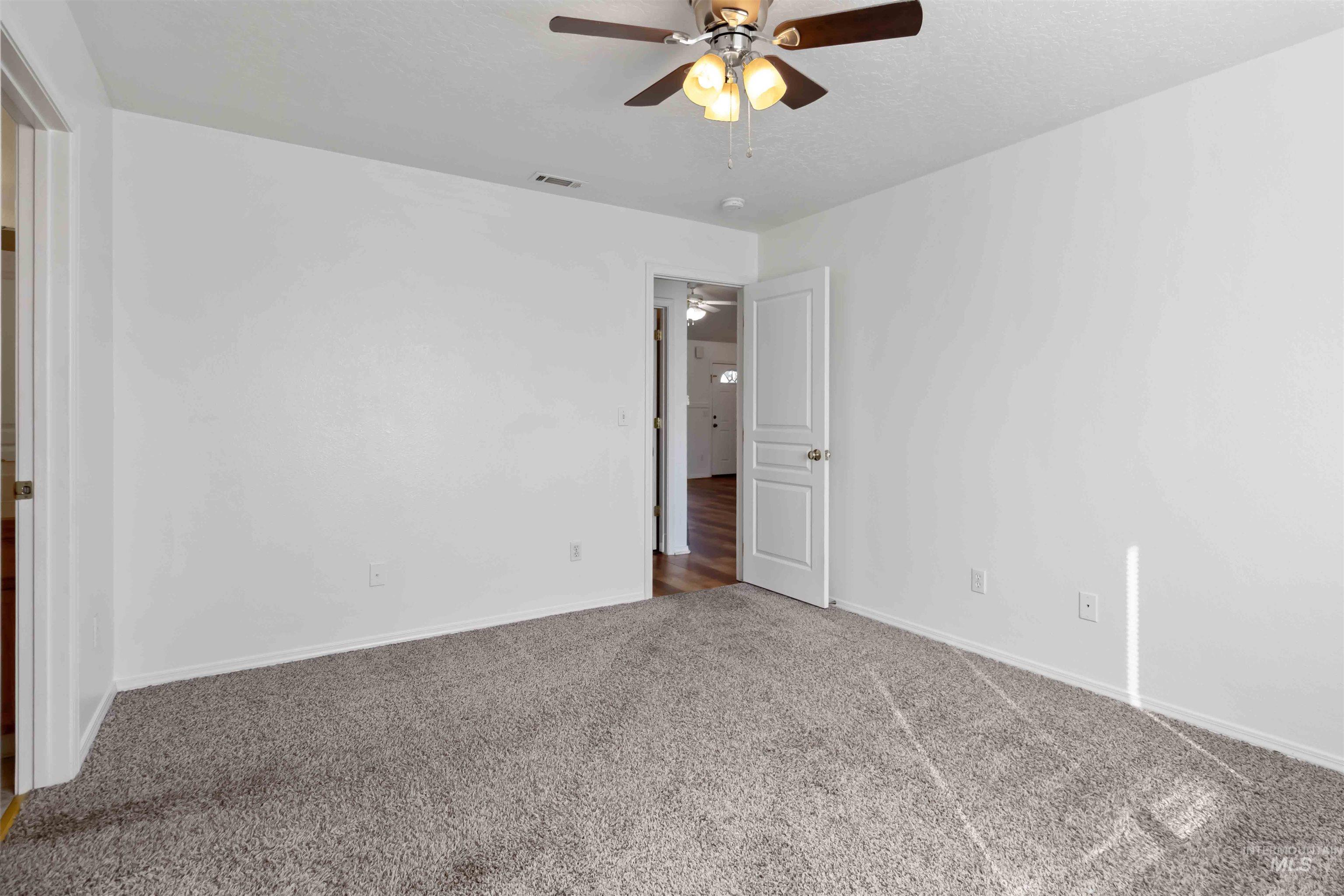 Empty room featuring carpet flooring and ceiling fan