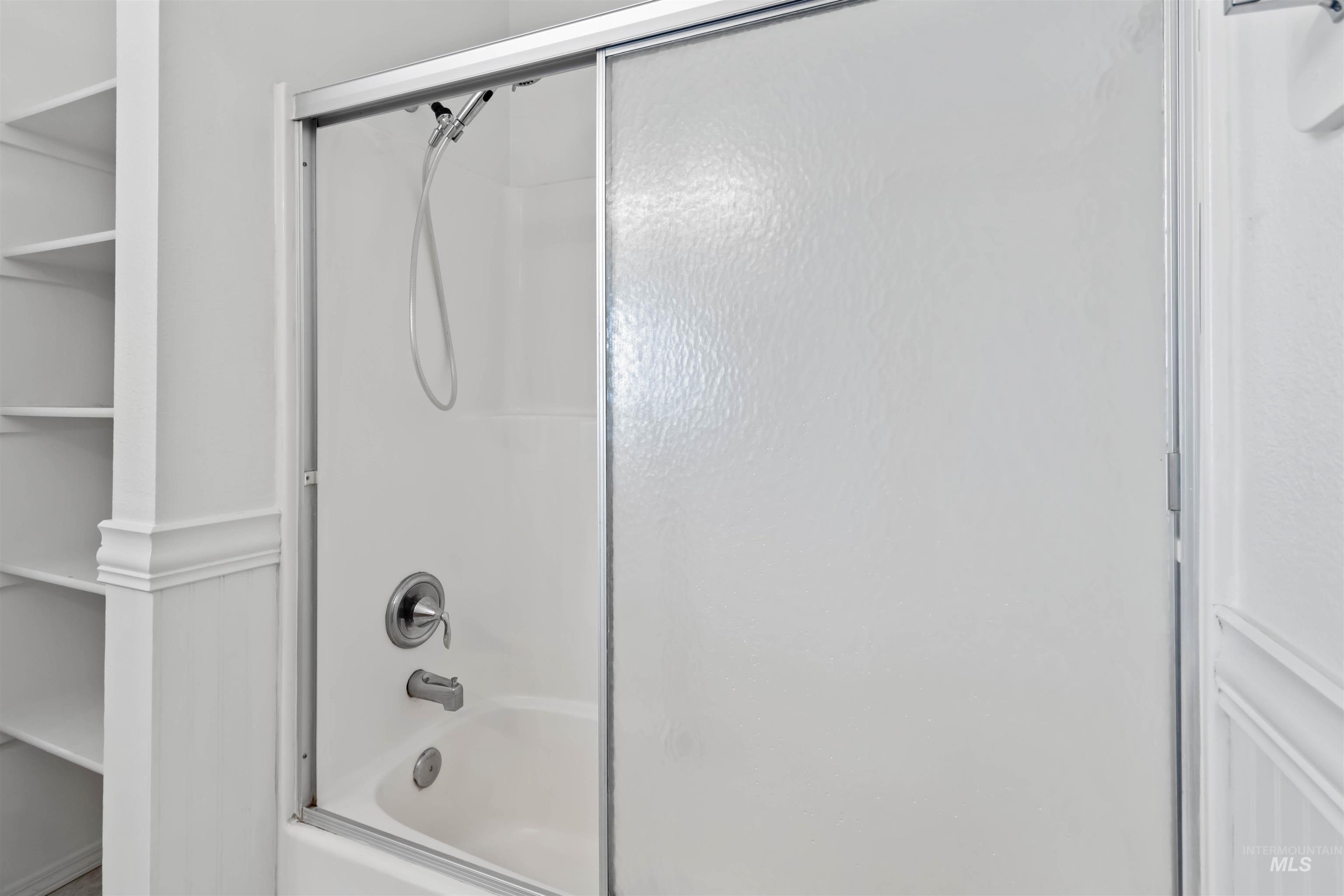 Full bath featuring shower / bath combination with glass door