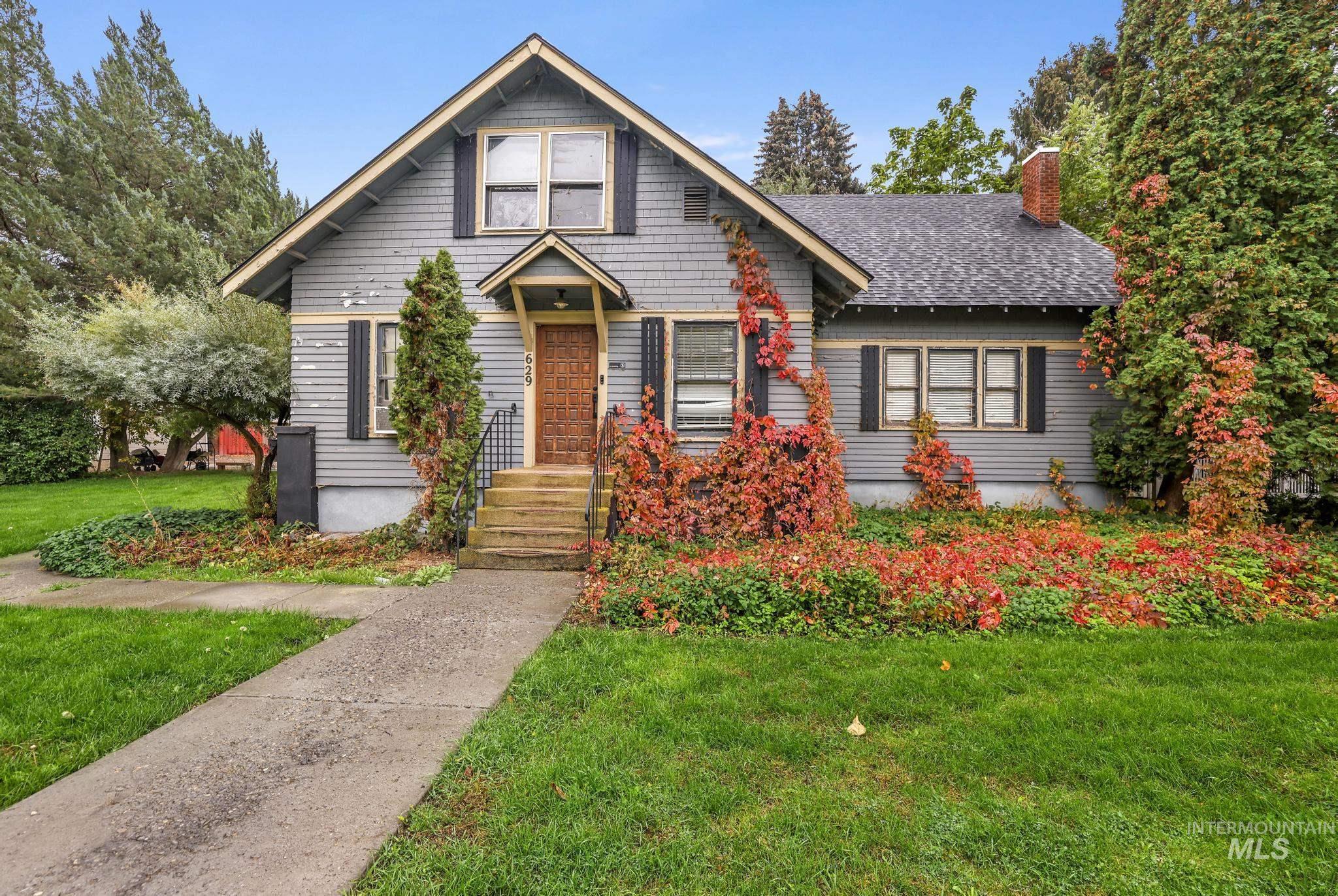 Bungalow with a front yard, a chimney, and a shingled roof