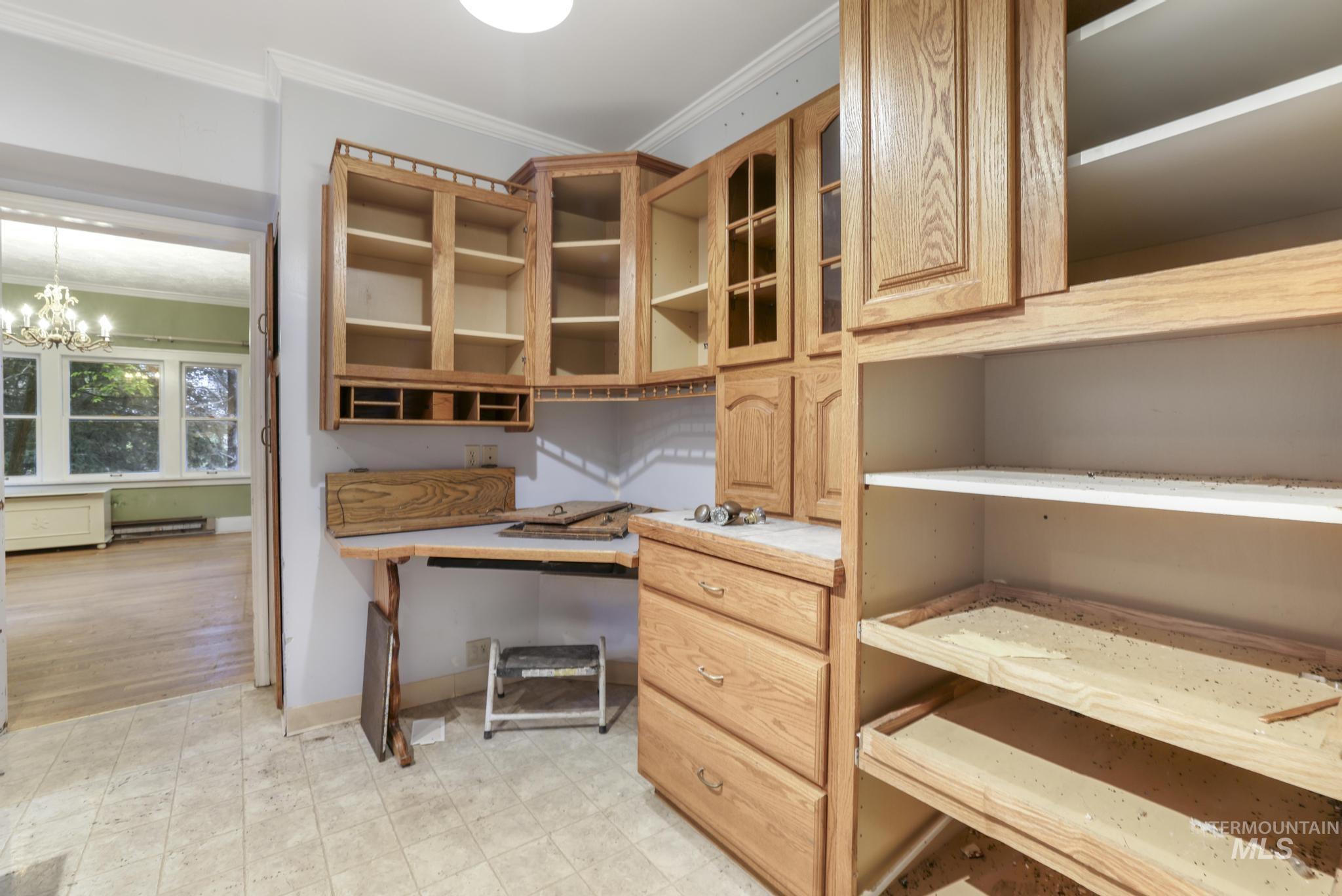 Unfurnished kitchen with crown molding, a chandelier, and a baseboard radiator