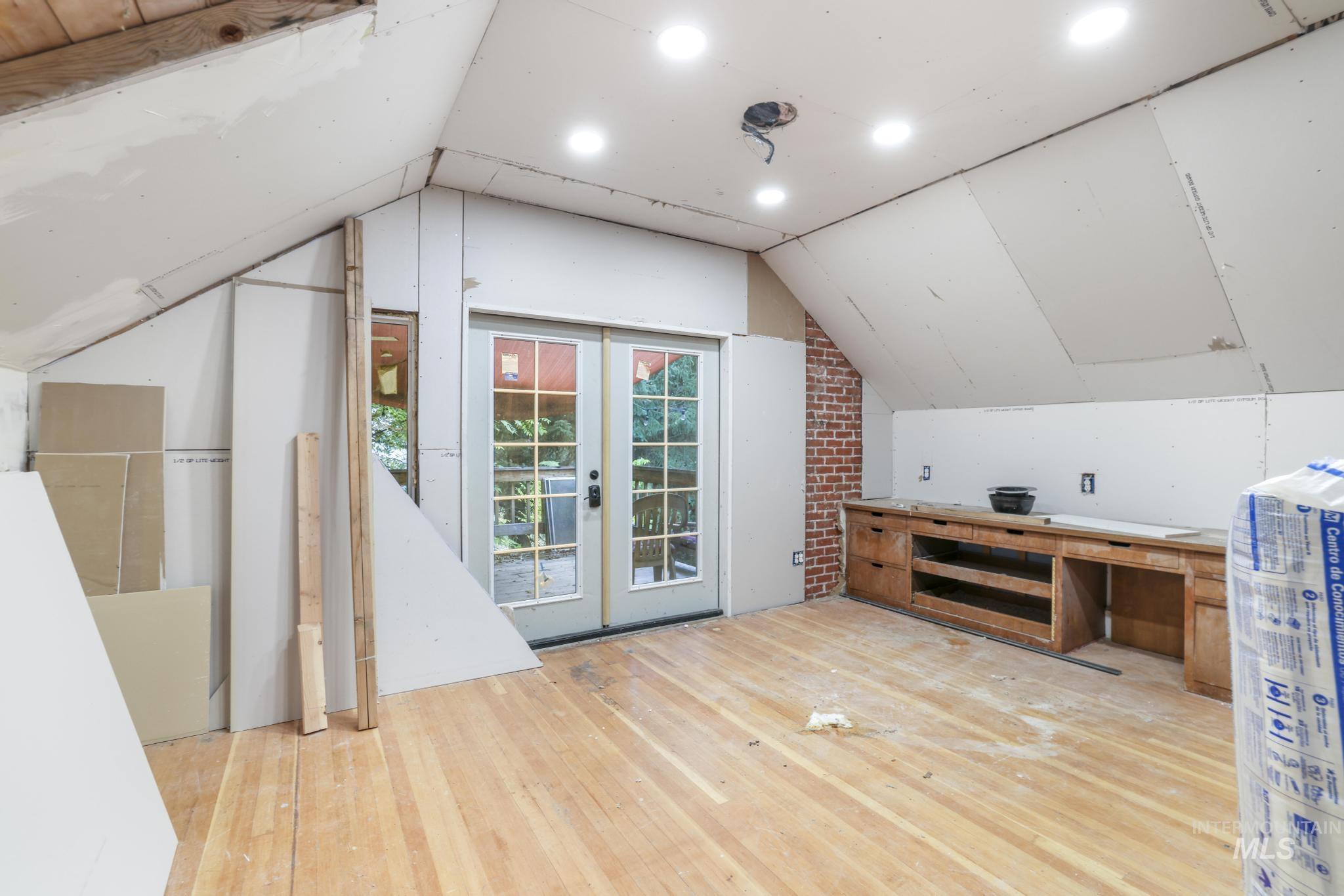 bedroom #3 with lofted ceiling, hardwood / wood-style flooring, and french doors