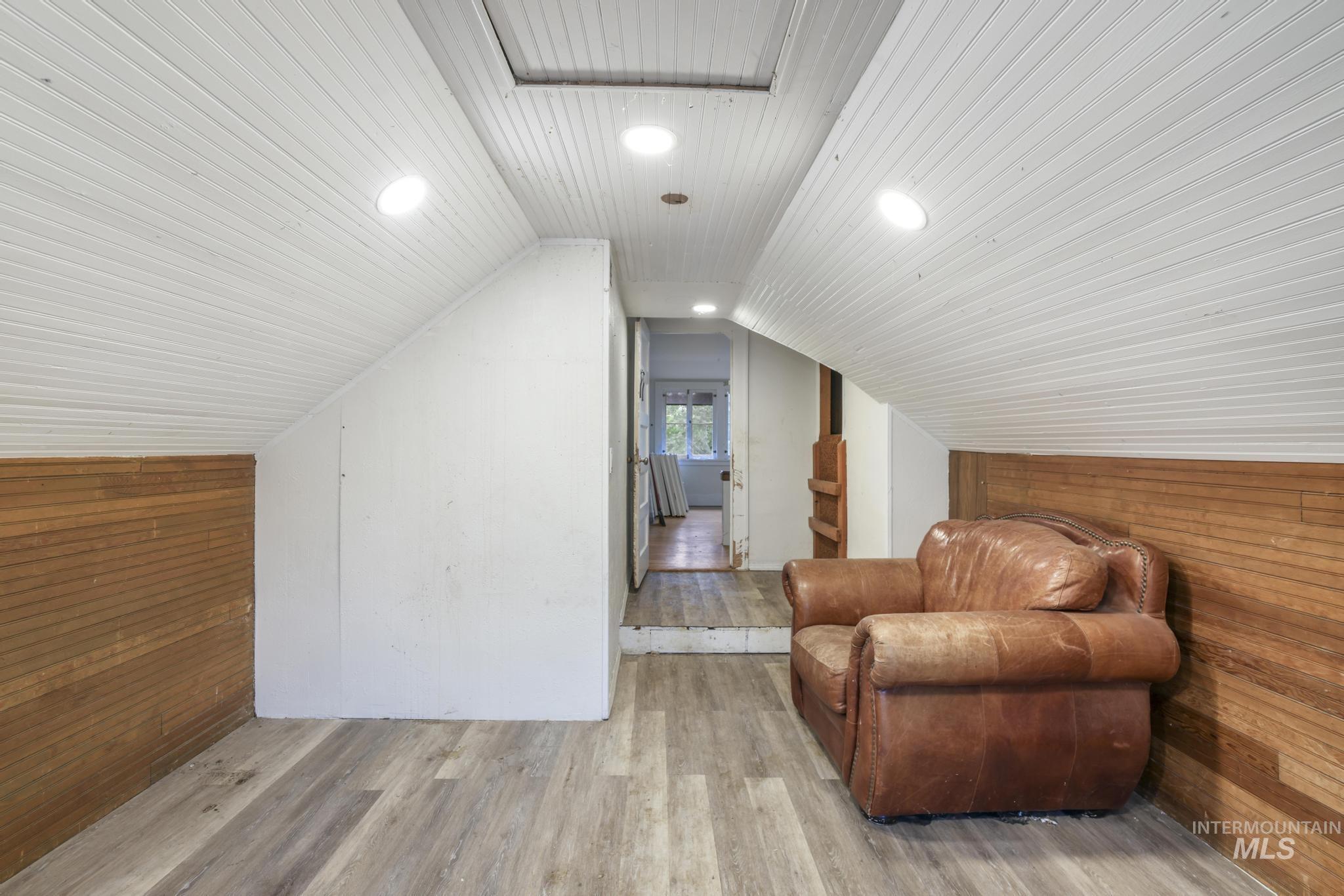 Bonus room featuring wooden walls, wood finished floors, vaulted ceiling, and recessed lighting
