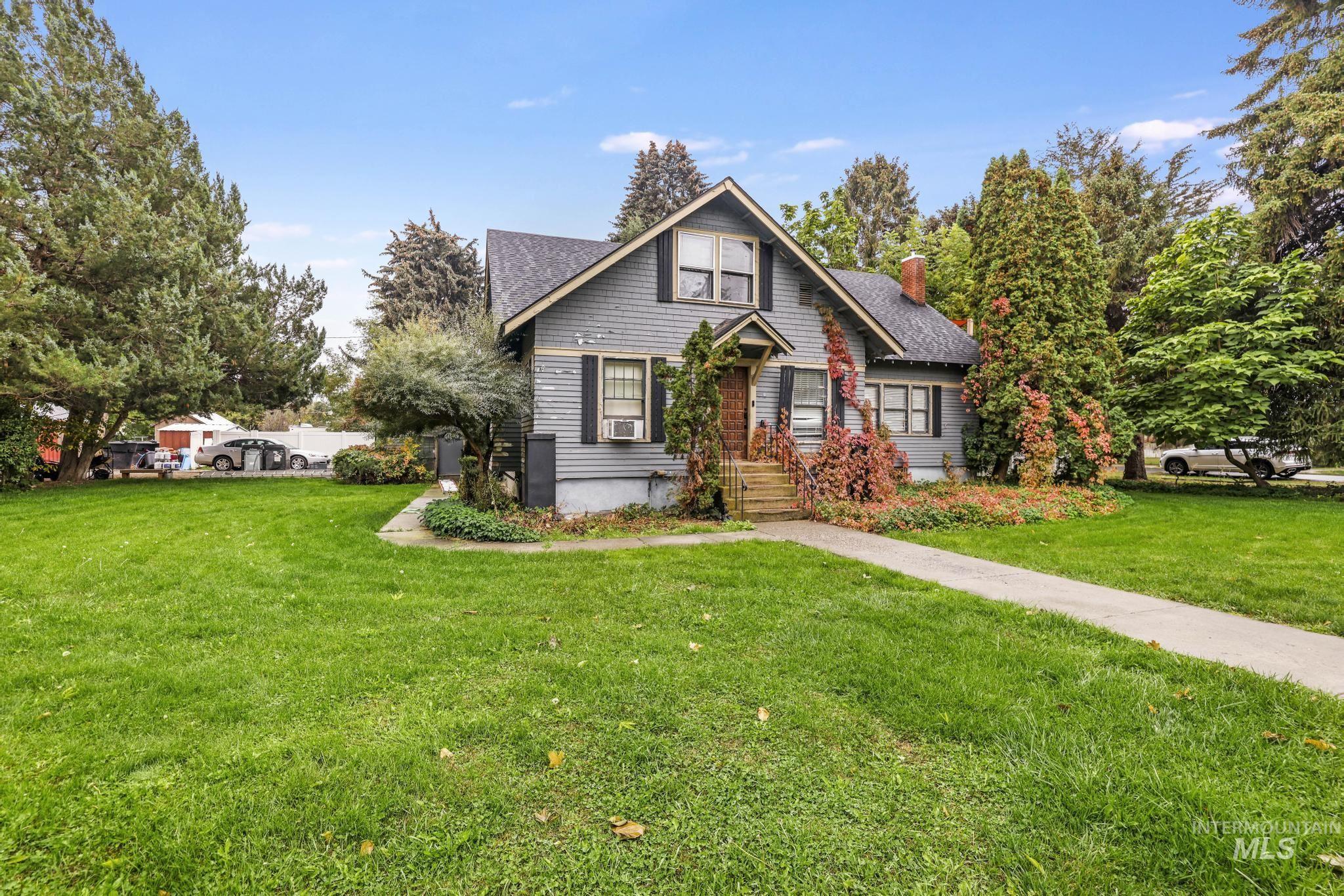Bungalow featuring a front lawn, a chimney, and roof with shingles