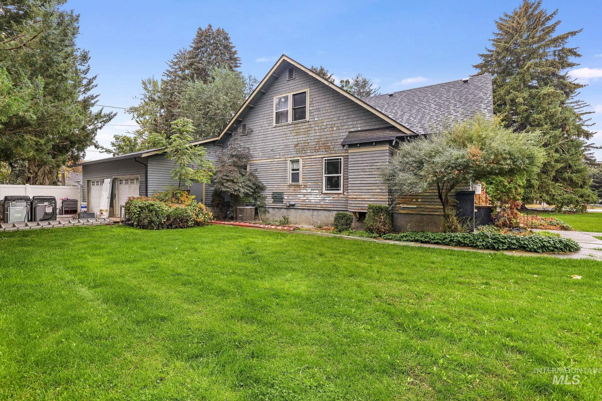 Rear view of property featuring a yard and roof with shingles