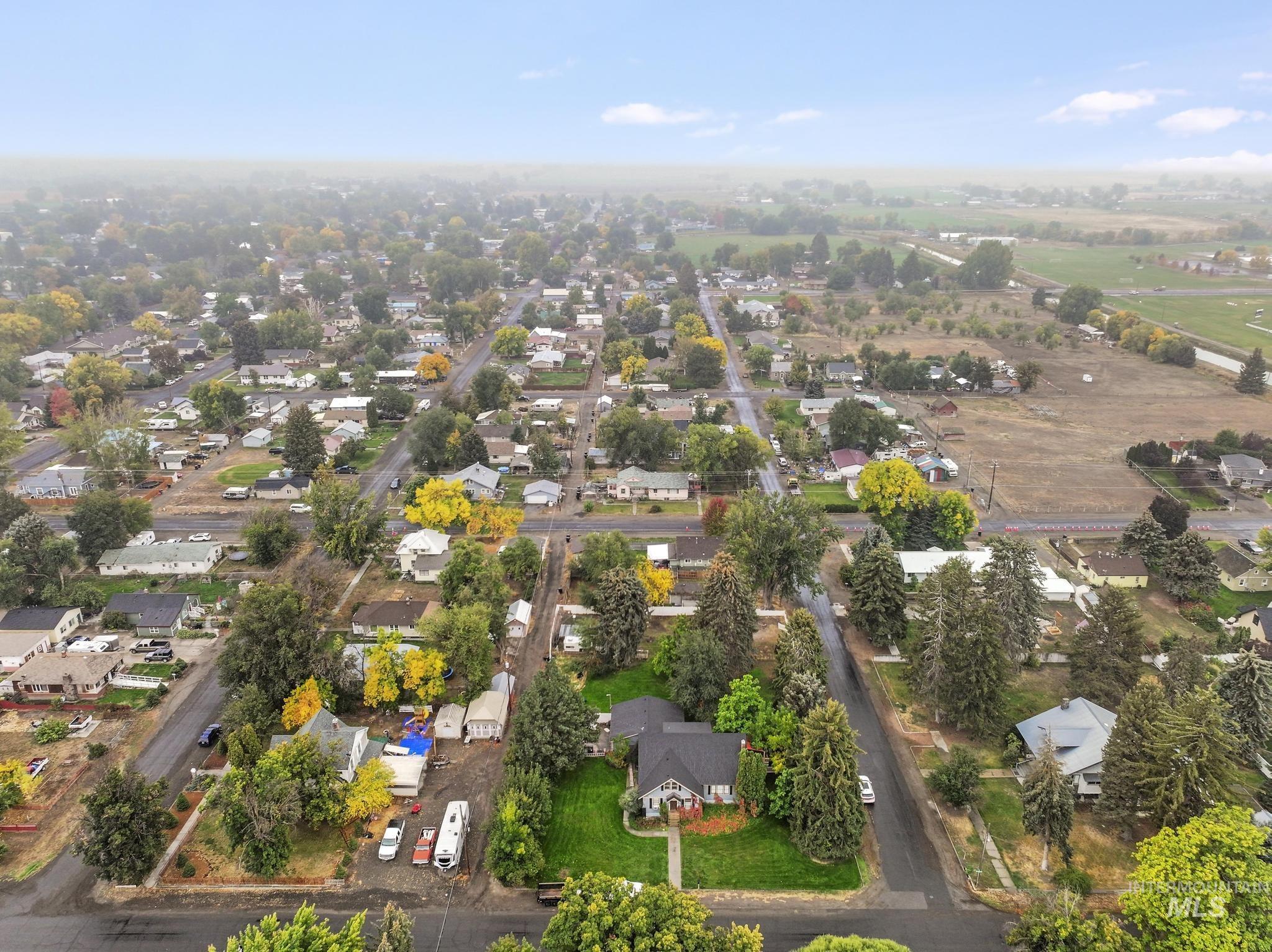 Aerial view of property and surrounding area with nearby suburban area