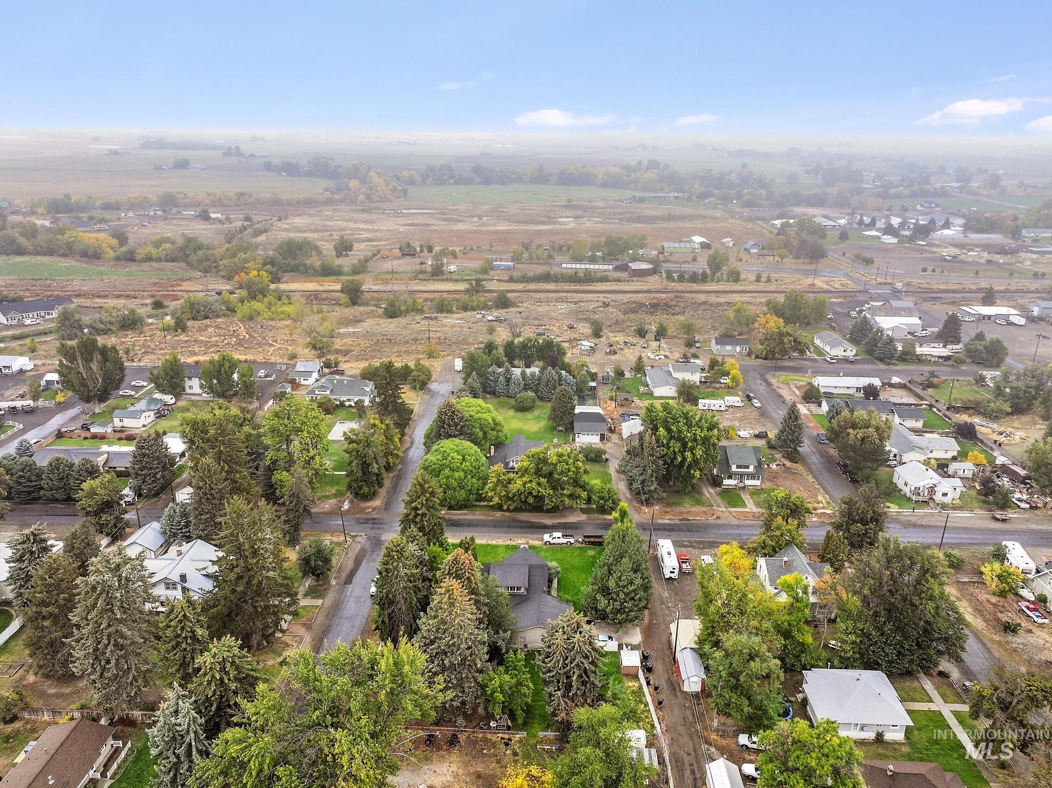 Aerial view of property and surrounding area with nearby suburban area