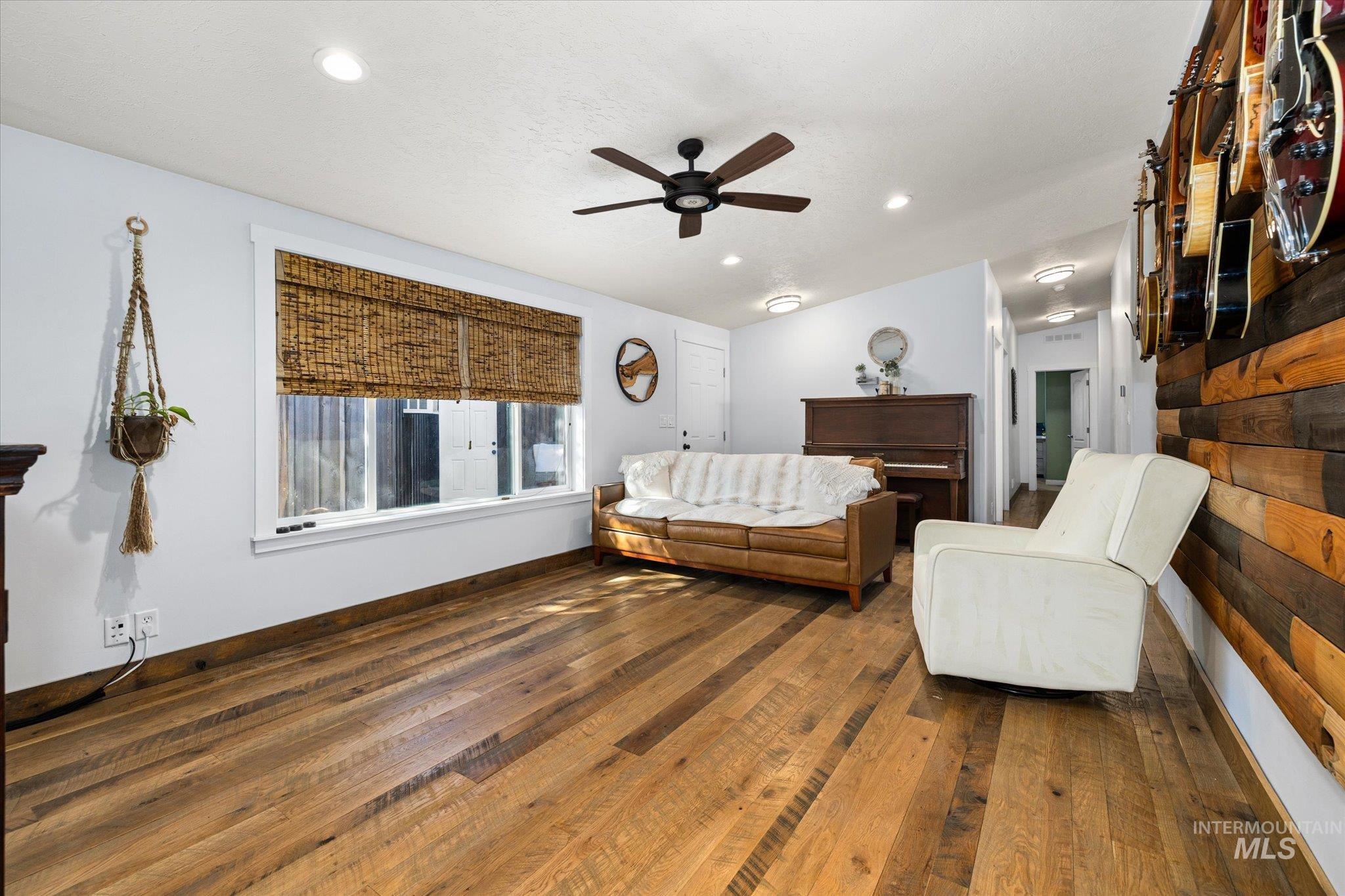 Living room featuring dark wood finished floors, a ceiling fan, and recessed lighting