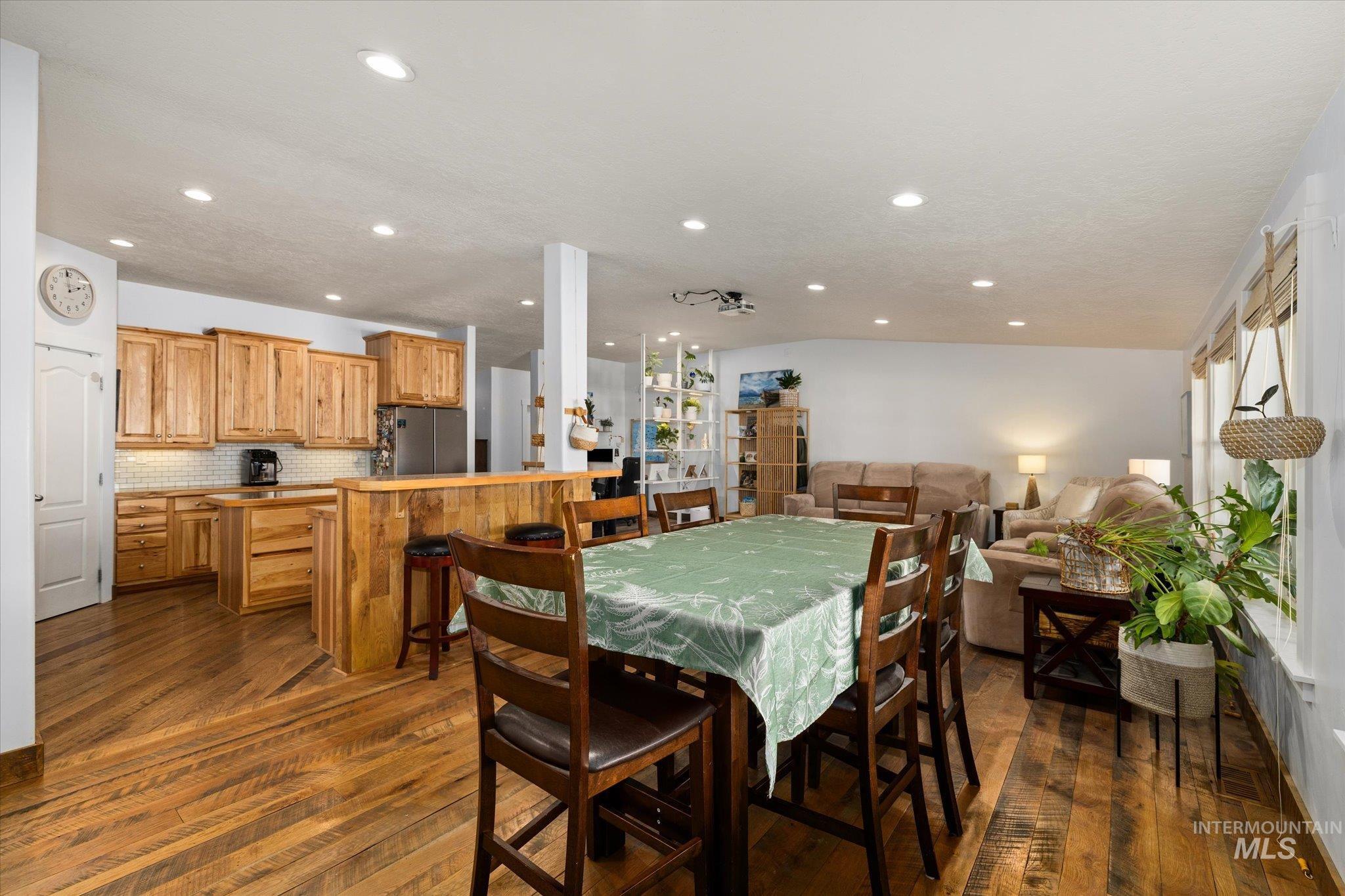 Dining space with dark wood finished floors and recessed lighting