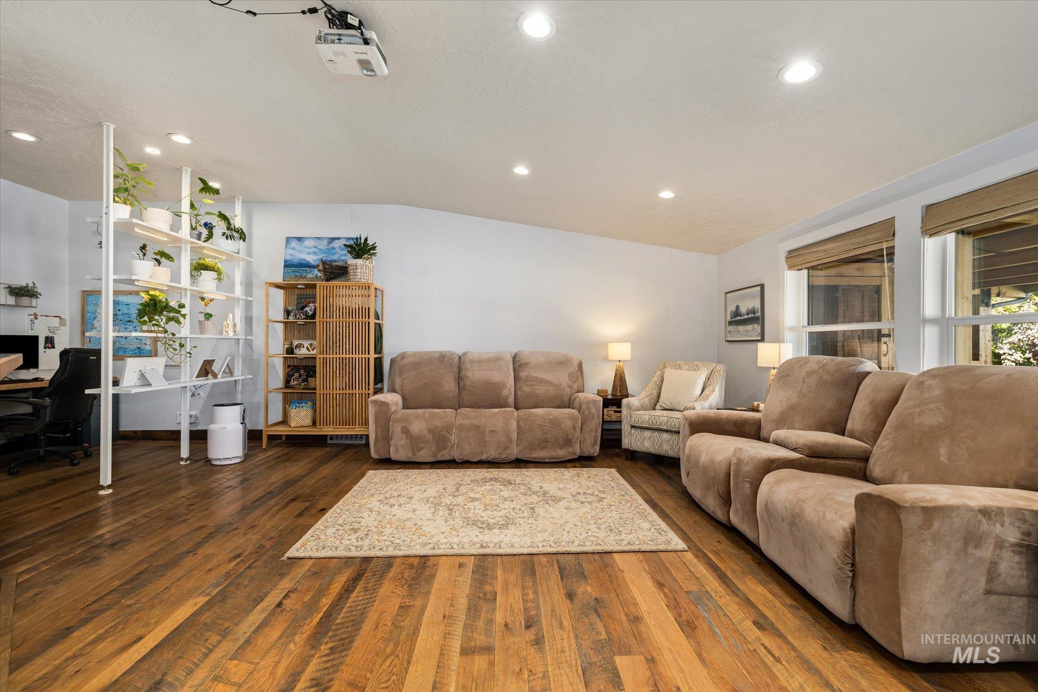 Living area featuring a desk, vaulted ceiling, recessed lighting, and dark wood-style flooring