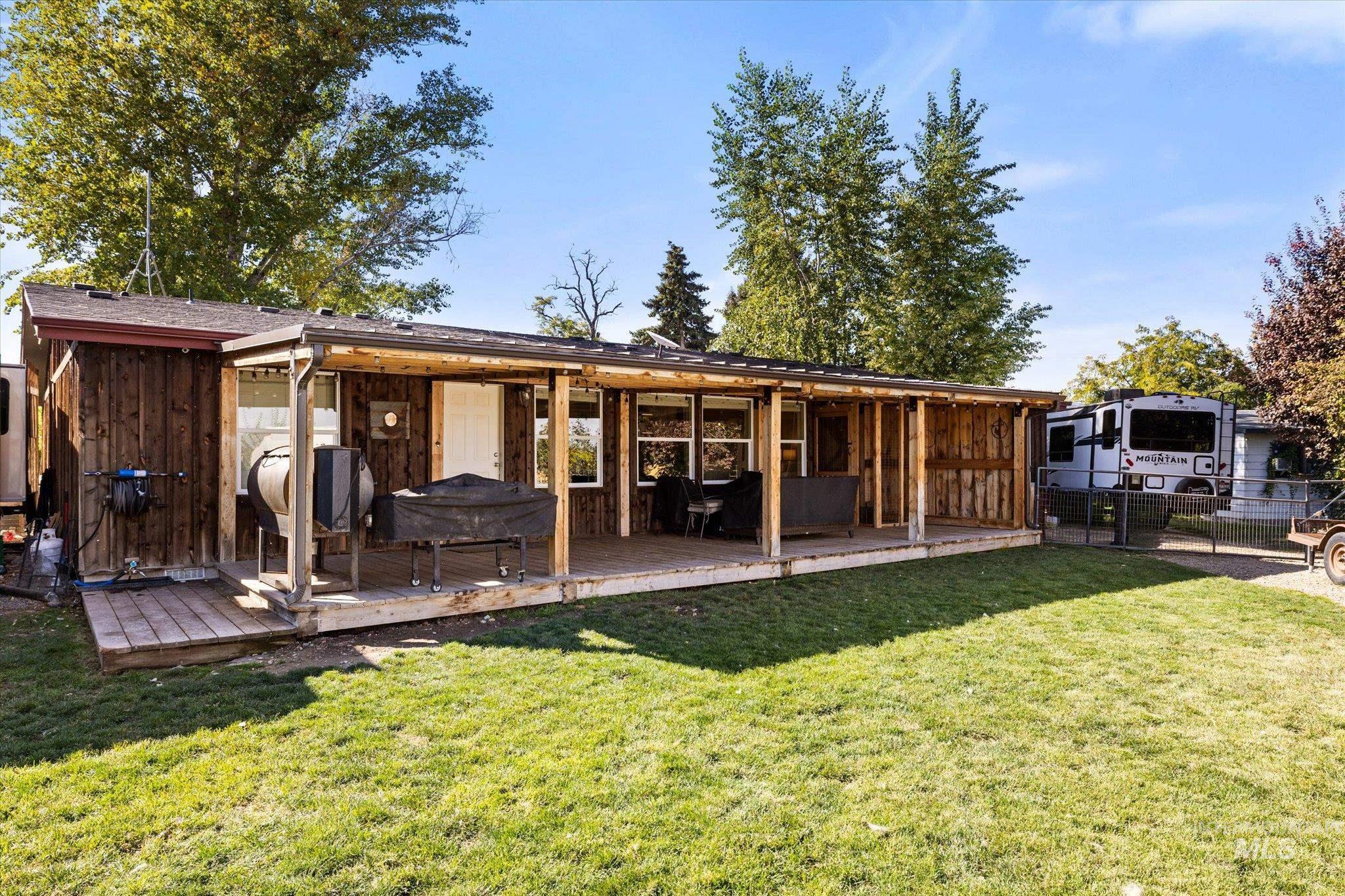 Back of house with a wooden deck and board and batten siding
