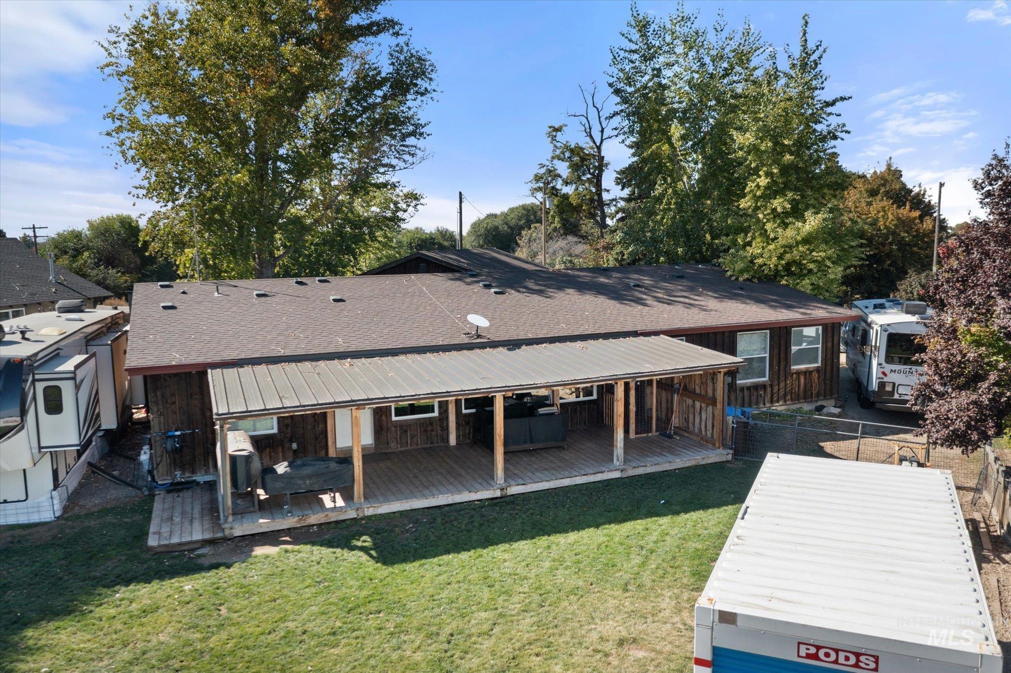 Rear view of house featuring a shingled roof and a deck