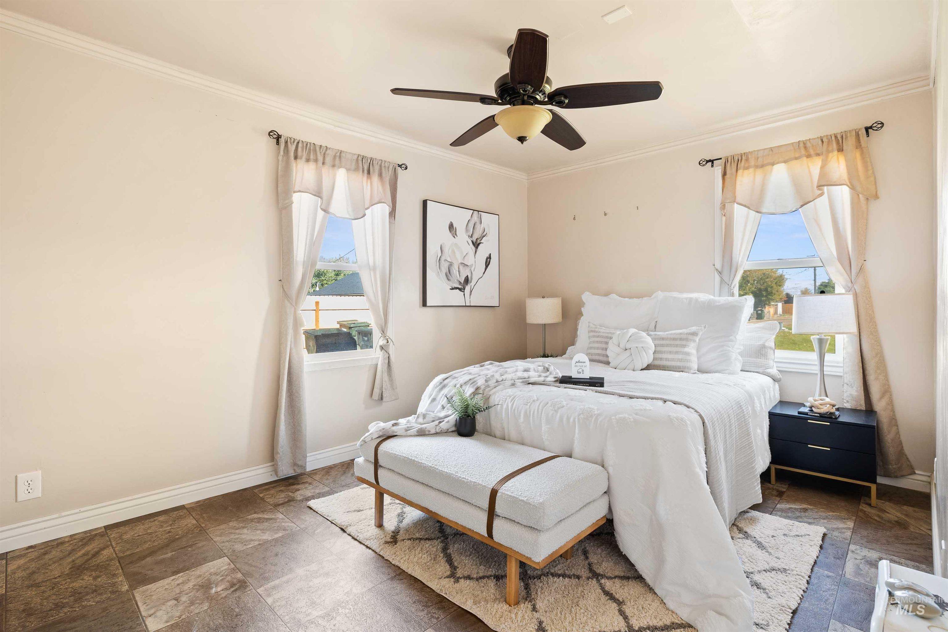 Bedroom with crown molding, a ceiling fan, and stone finish flooring