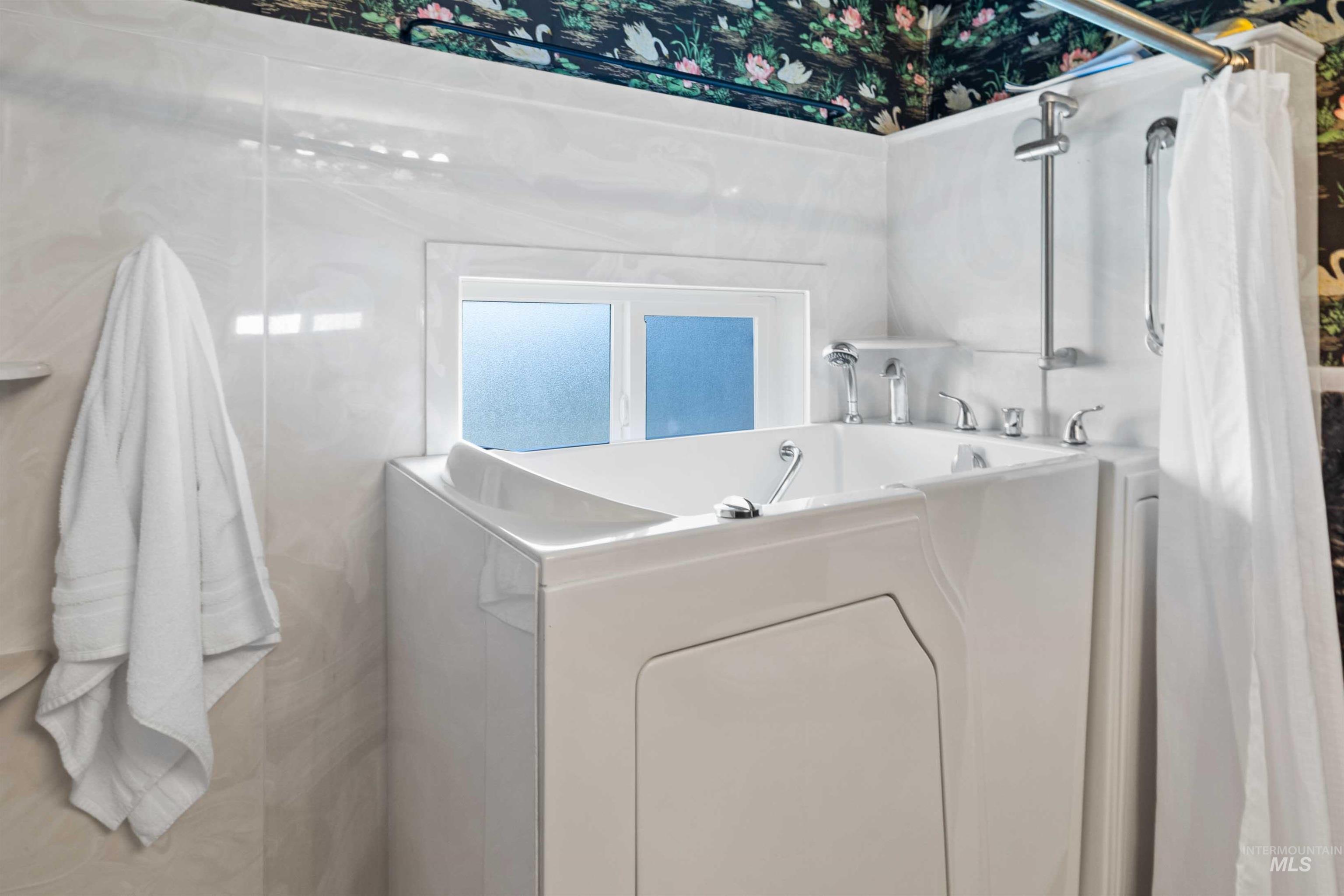 Bathroom with a garden tub and washer / dryer