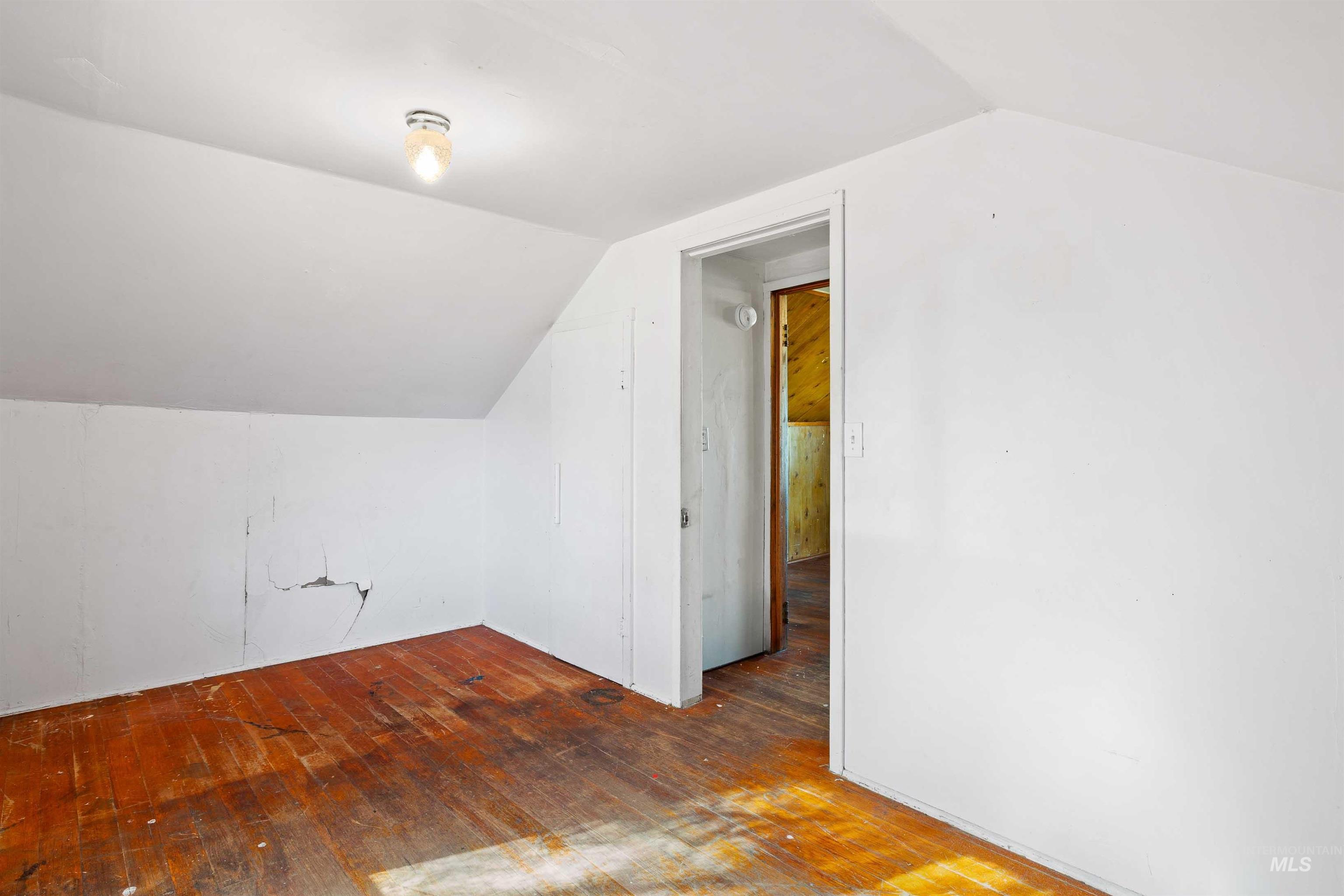Bonus room with wood-type flooring and lofted ceiling