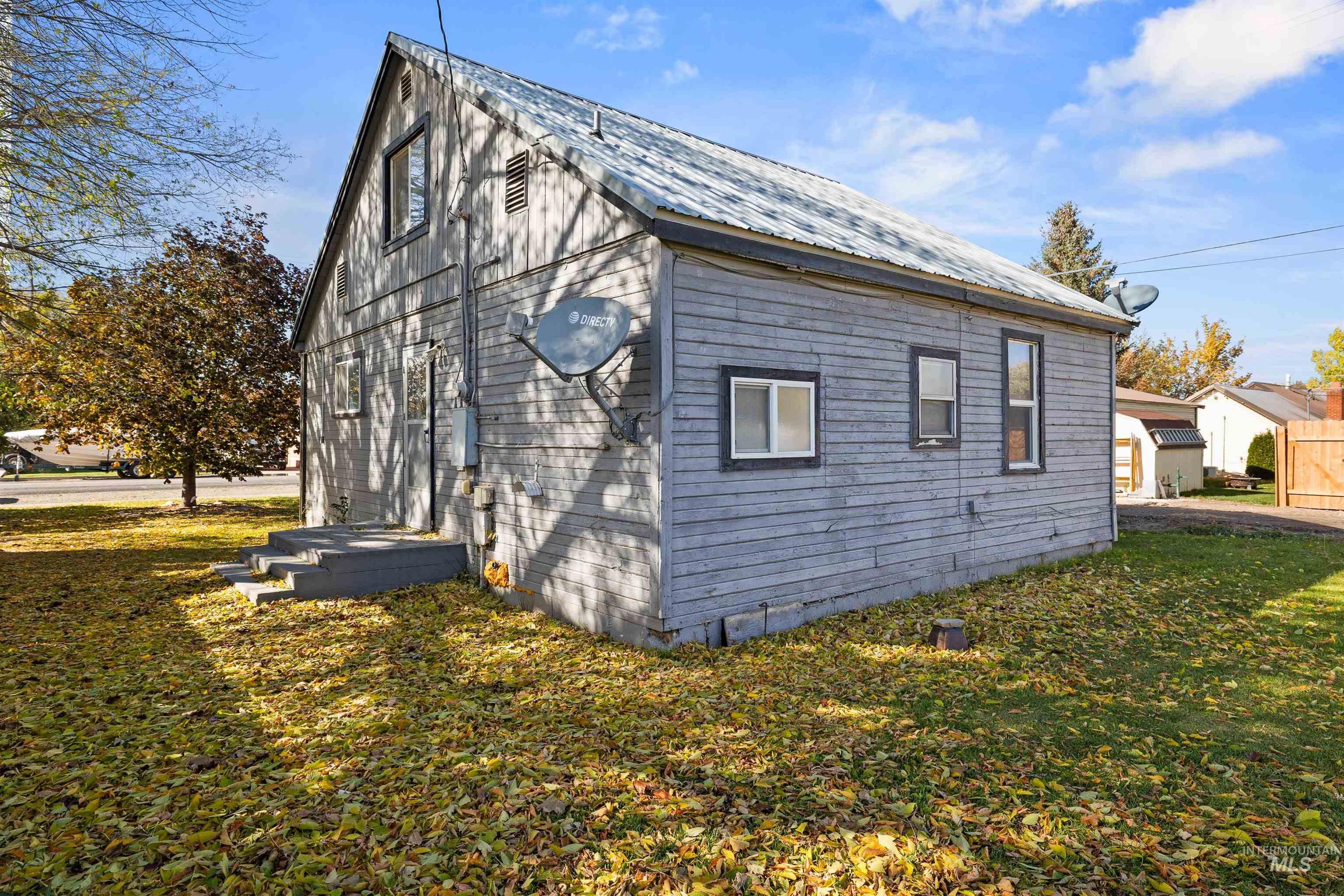 View of side of property featuring a lawn and a metal roof