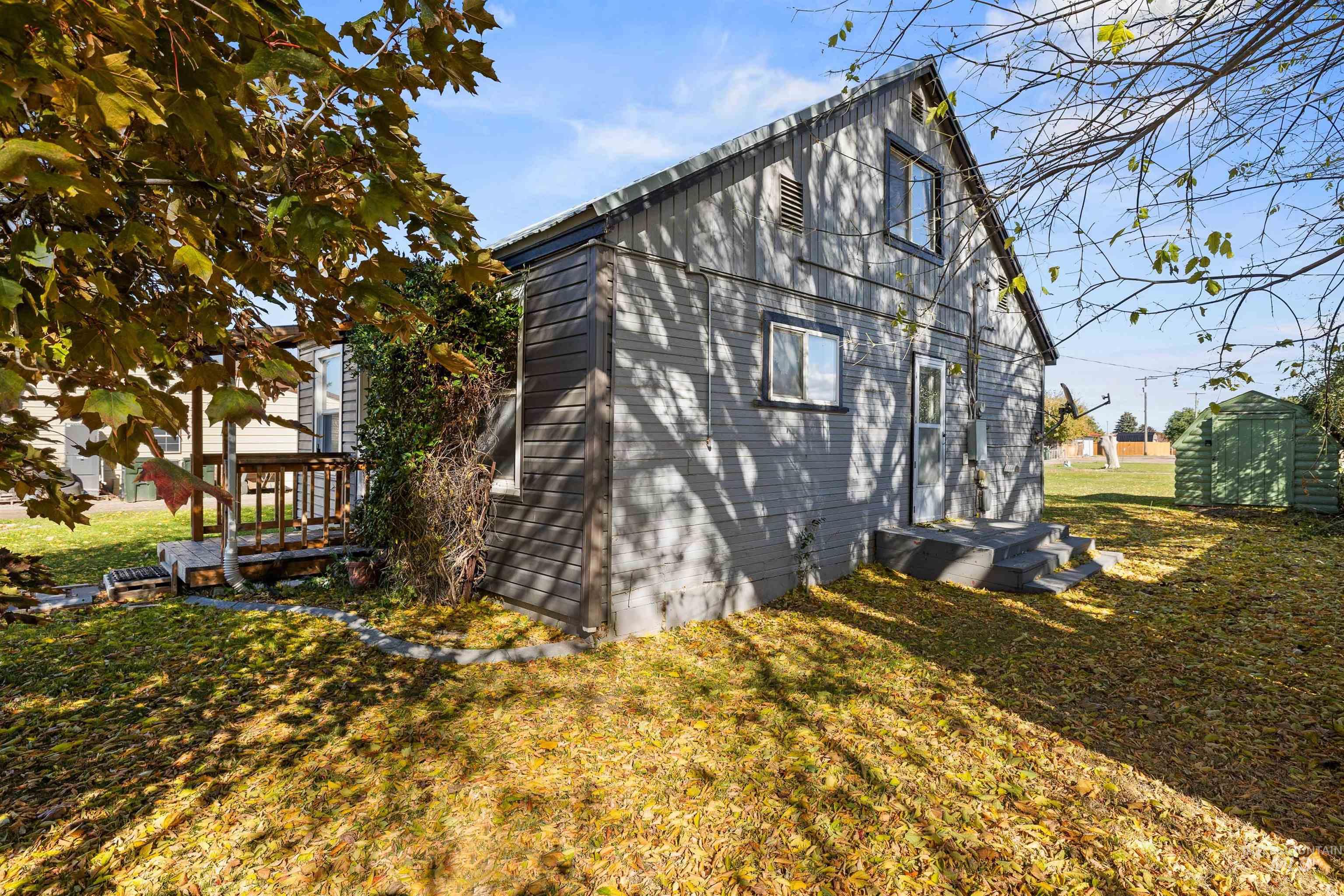 View of side of home with a lawn and a storage shed