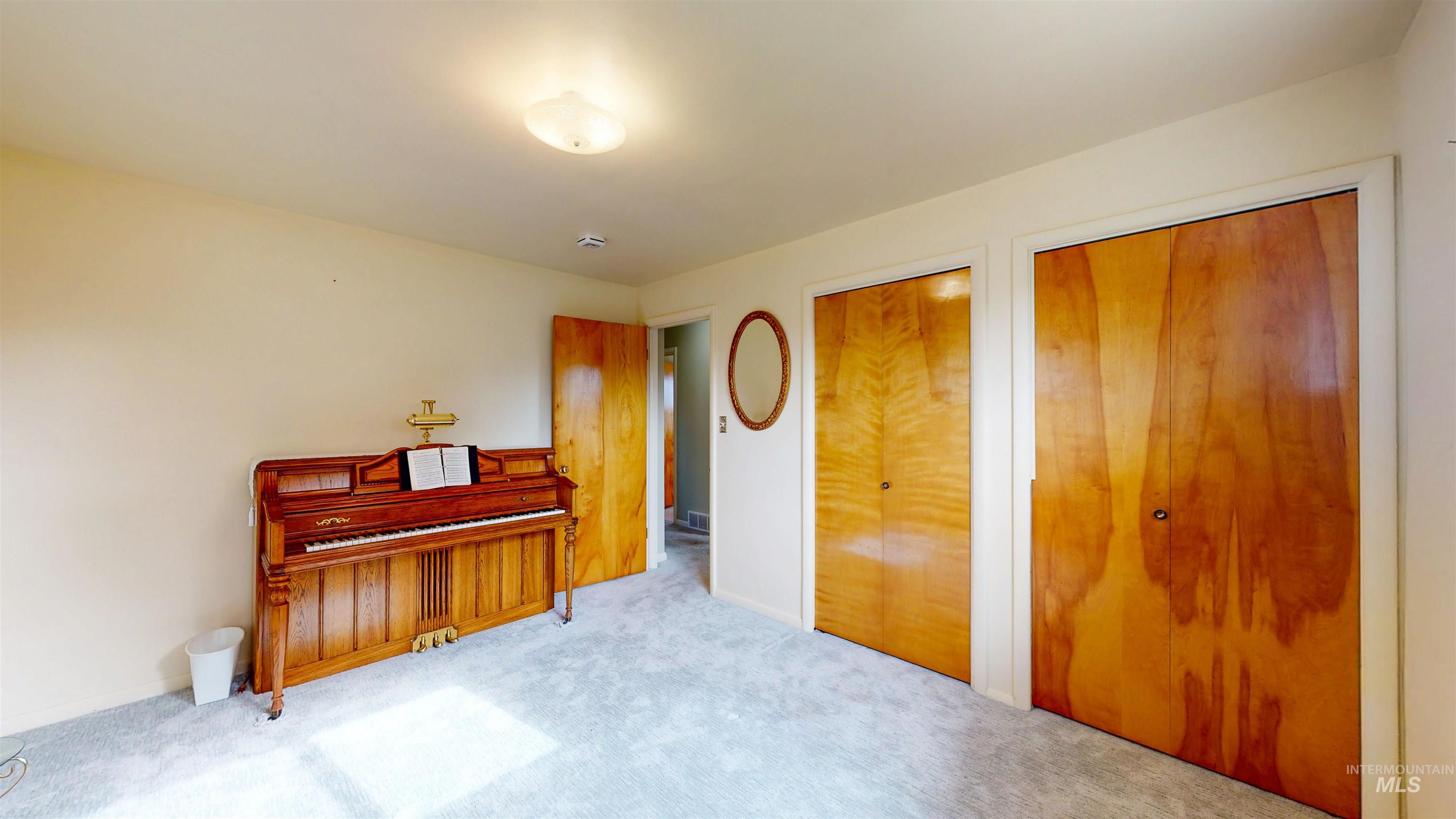 Bedroom featuring multiple closets and carpet