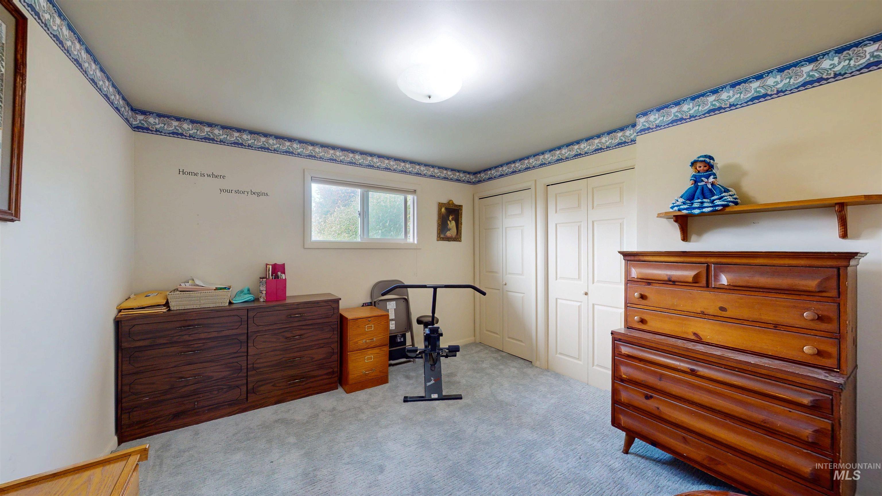 Bedroom featuring multiple closets and light colored carpet