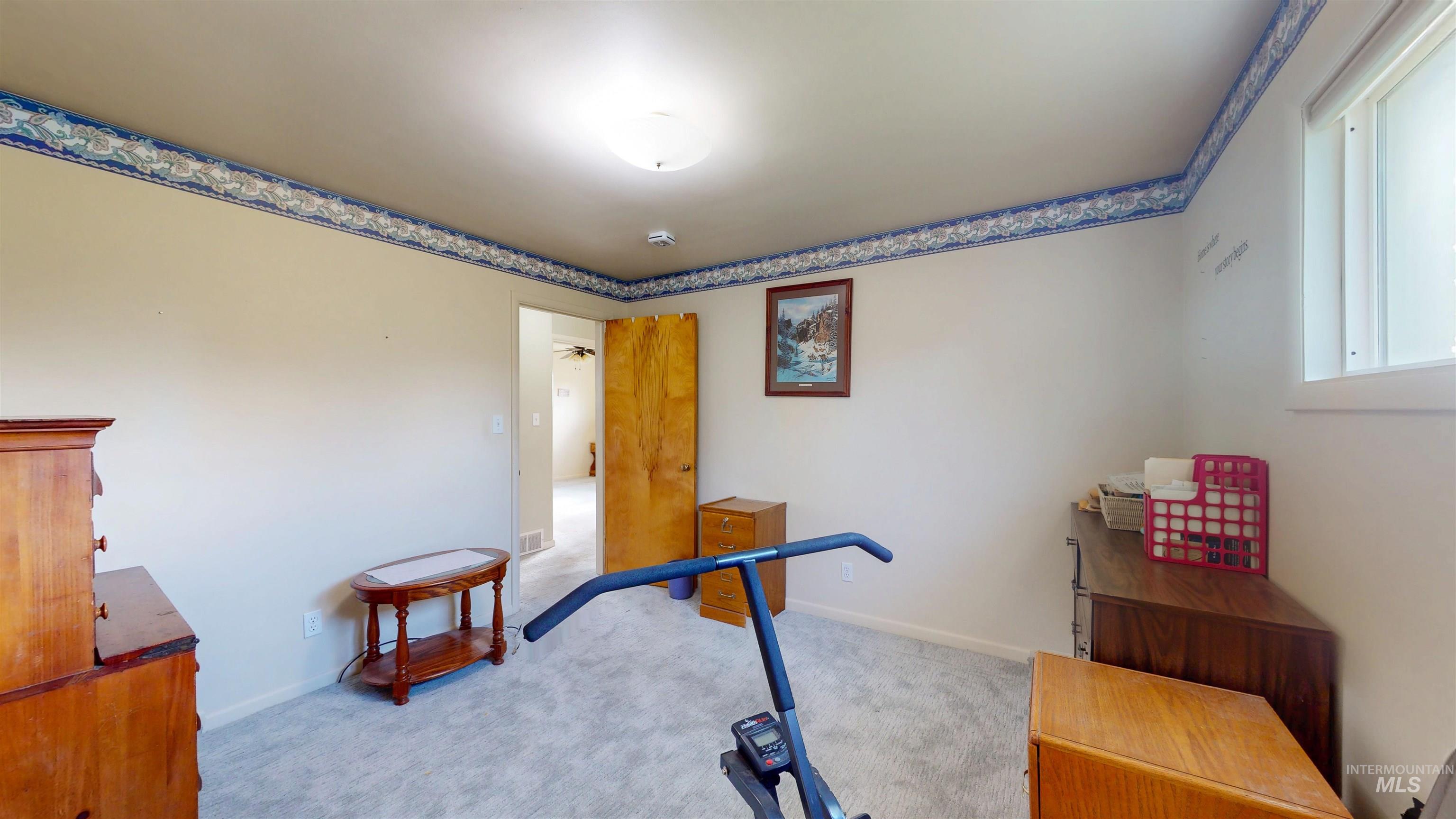 Workout area with light carpet and baseboards