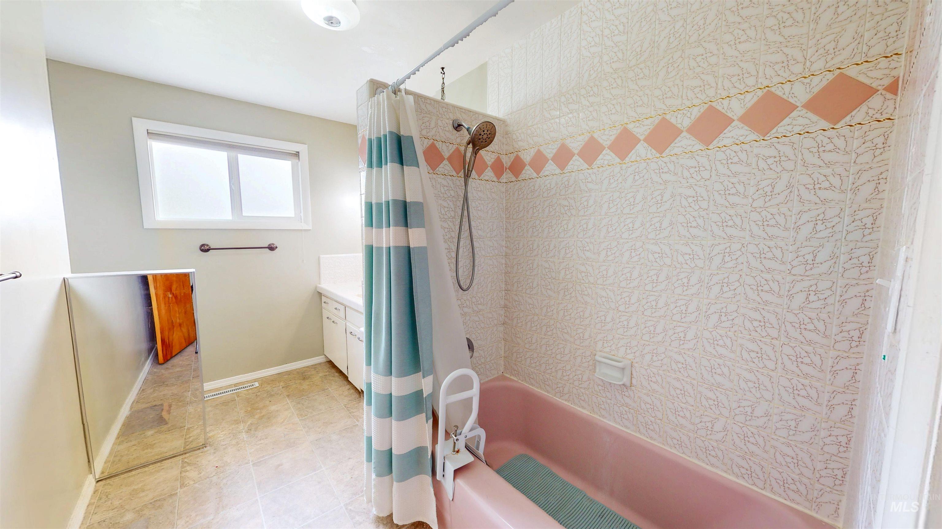 Full bathroom featuring shower / tub combo, vanity, and light tile patterned flooring