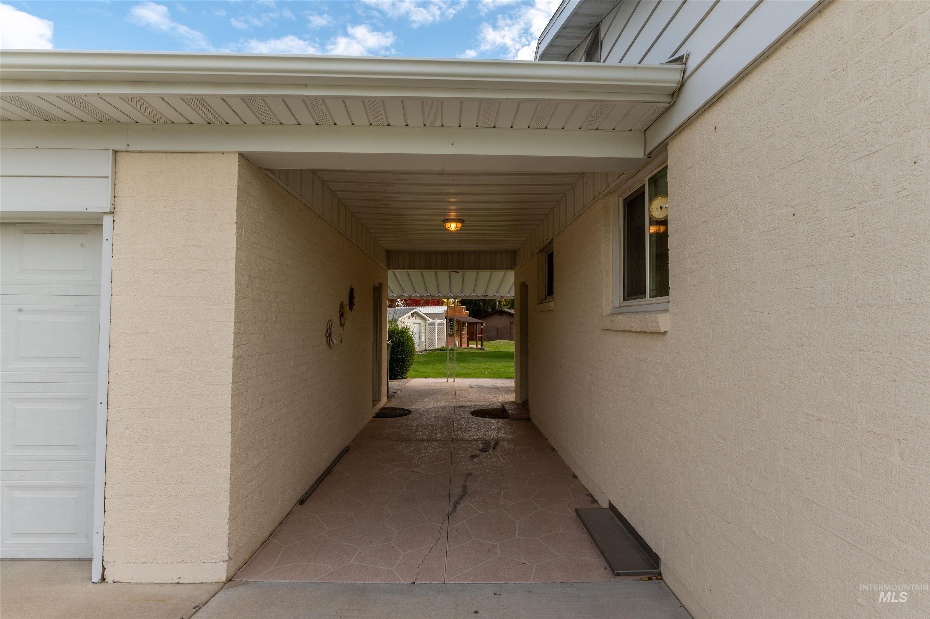 View of side of property with a patio and a garage